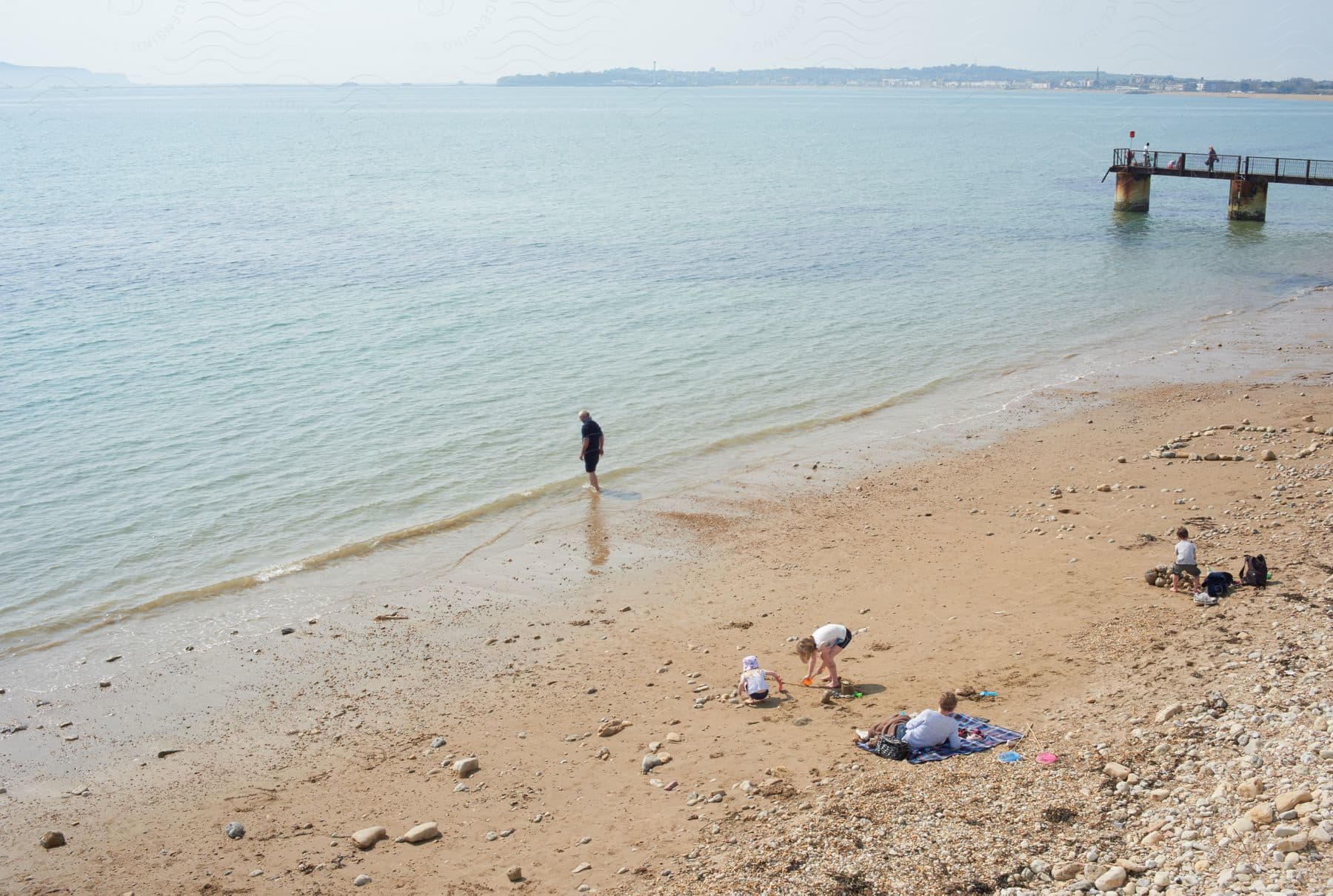 A man standing on a beach looking into the ocean