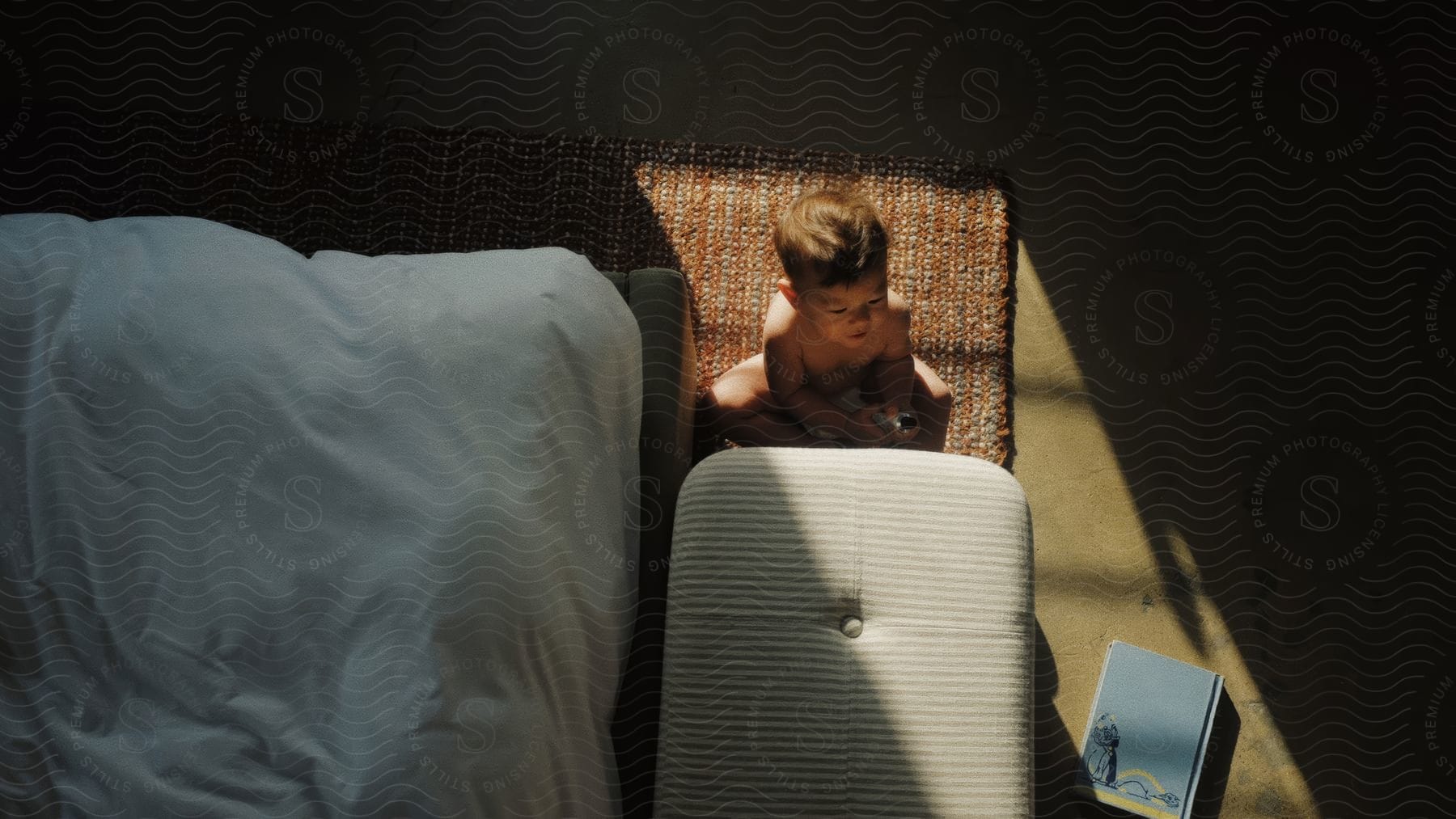 A child sitting on the floor in a bedroom