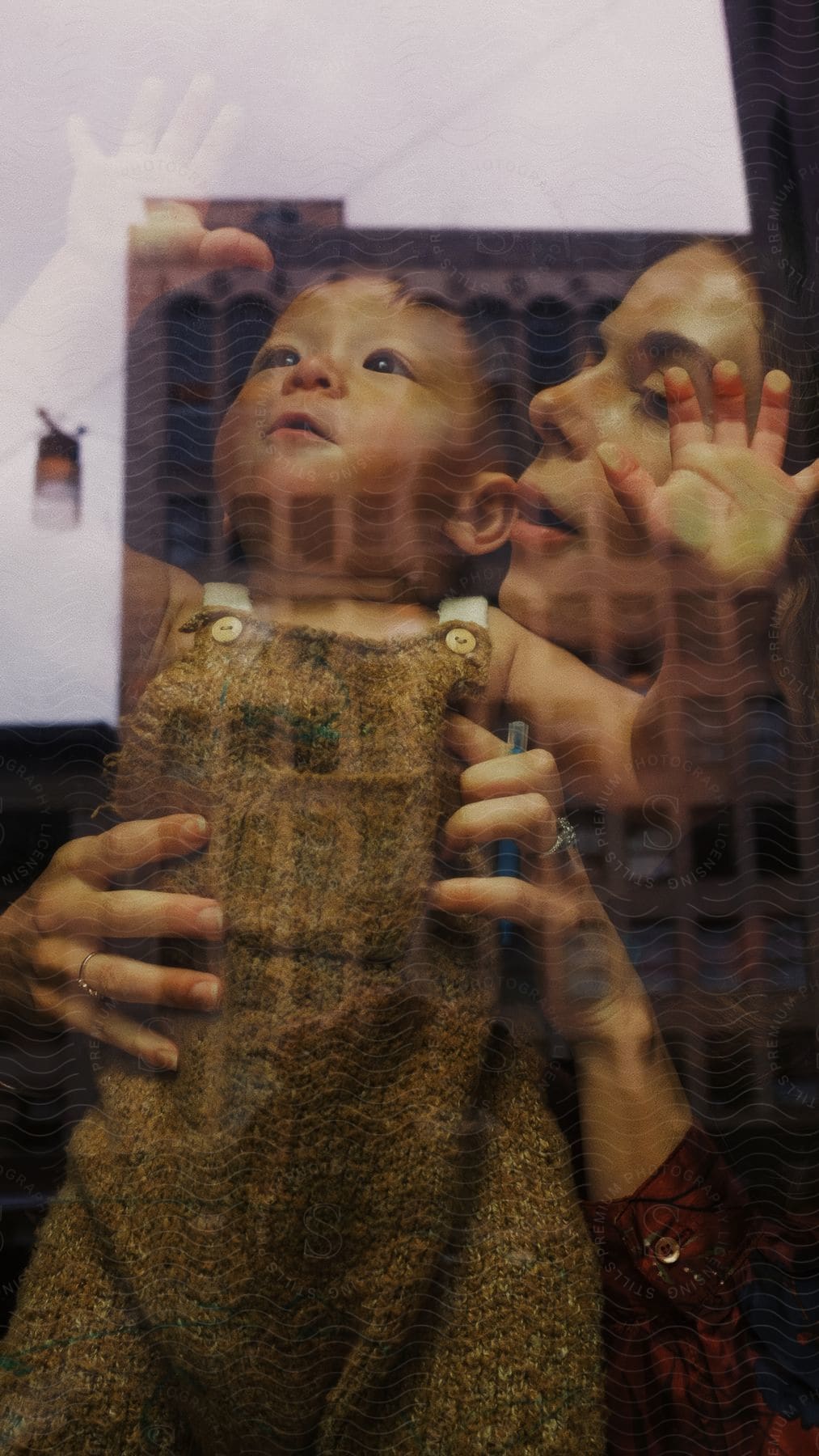 Portrait of toddler and woman as seen through window reflection