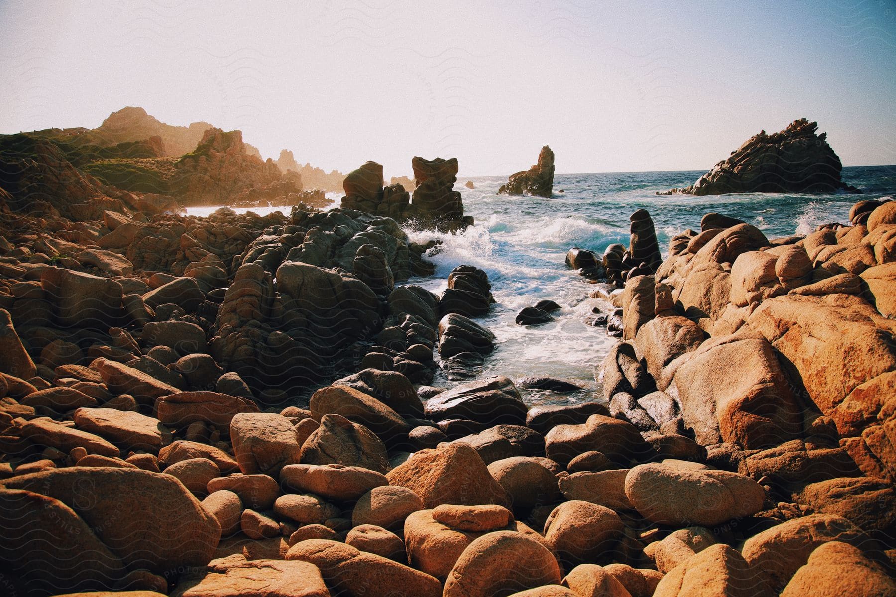 Waves breaking against the rocks on the beach at dawn.