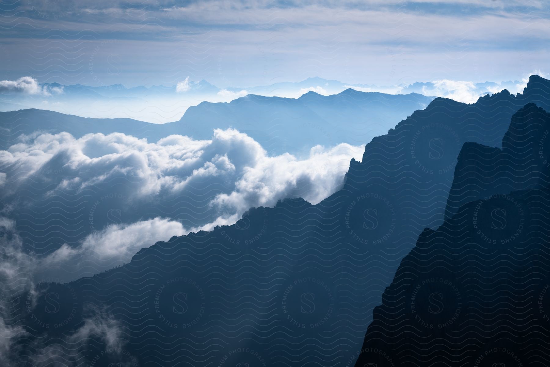 Panorama of mountain silhouettes with cliffs and clouds passing by during the day