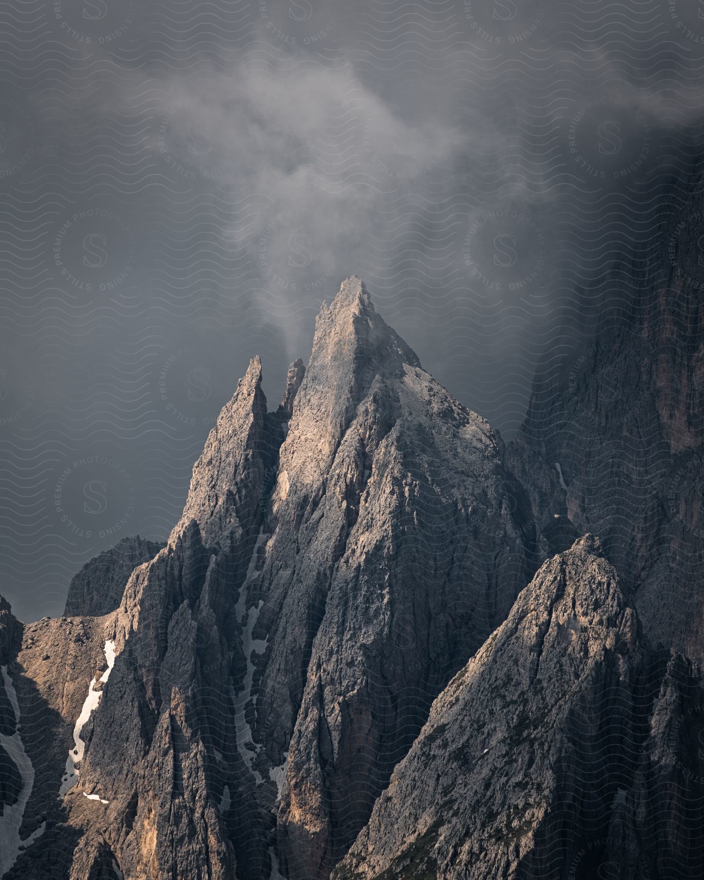 Rocky mountain peak with natural weathering and cliffs on a cloudy day