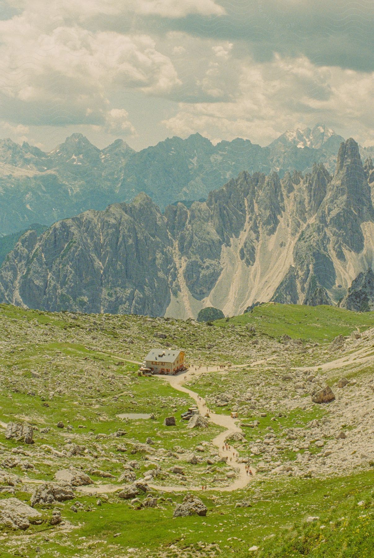 House on a plateau with mountains around on a cloudy day