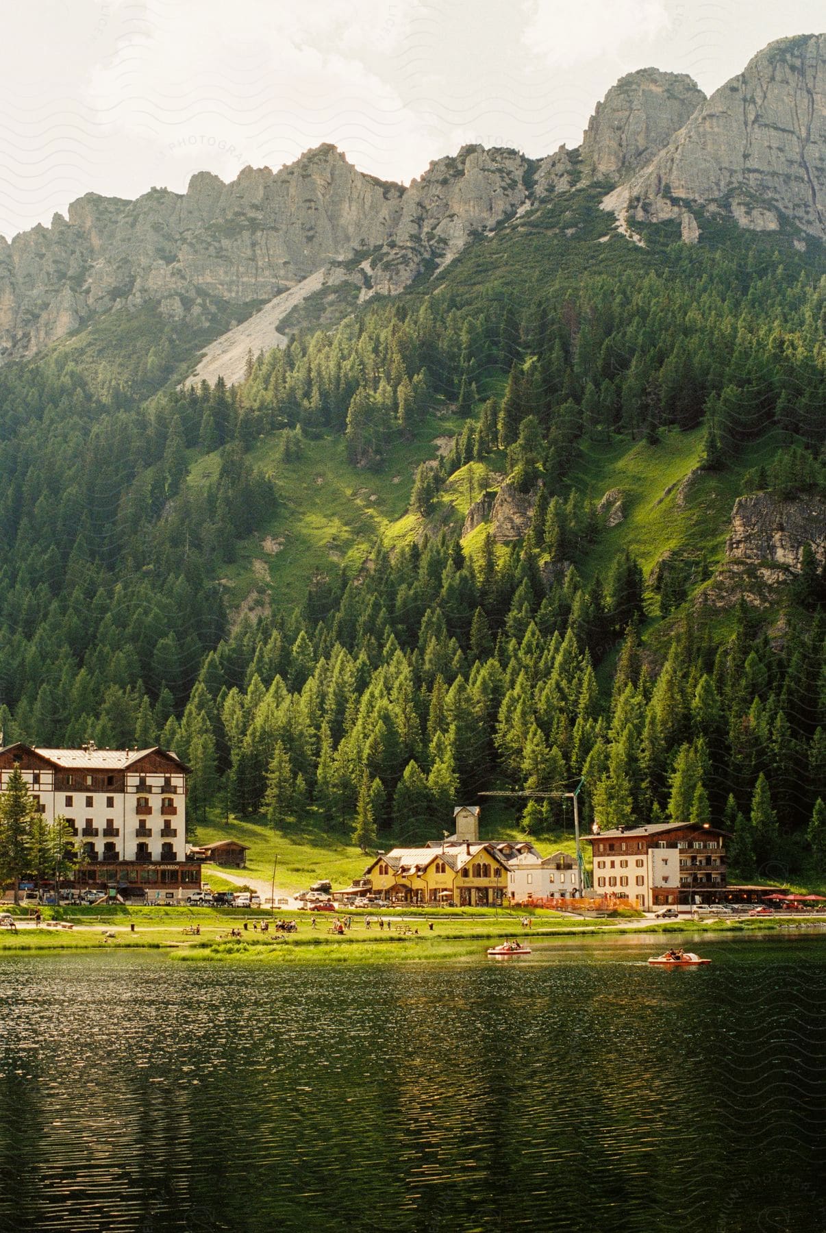 Buildings near massive mountains and a lake