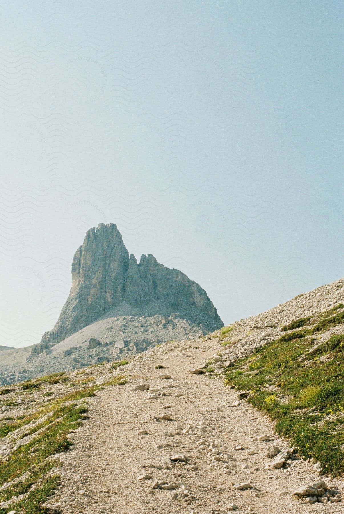 A view of some mountains from a trail on a sunny day