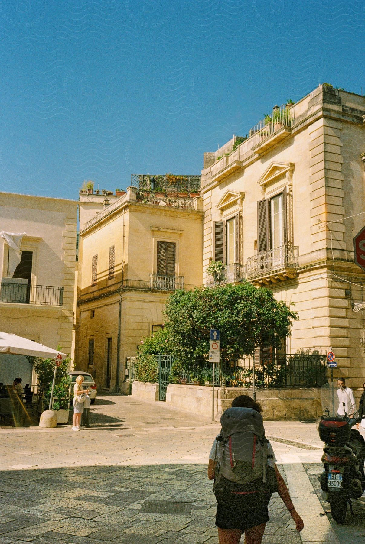 A backpacker walking on a european plaza.