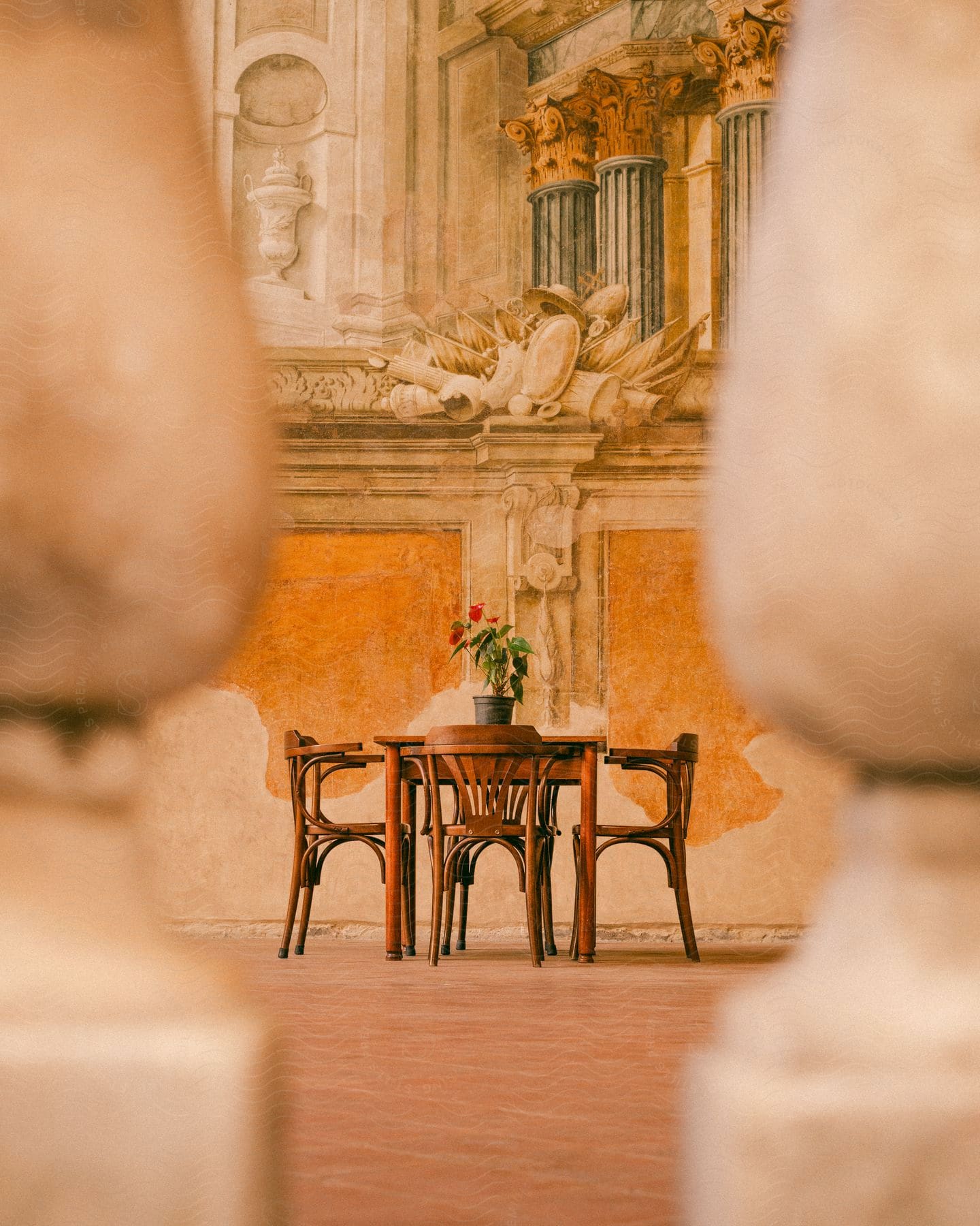 A cozy atmosphere with a round table and four chairs arranged on a terracotta tiled floor.