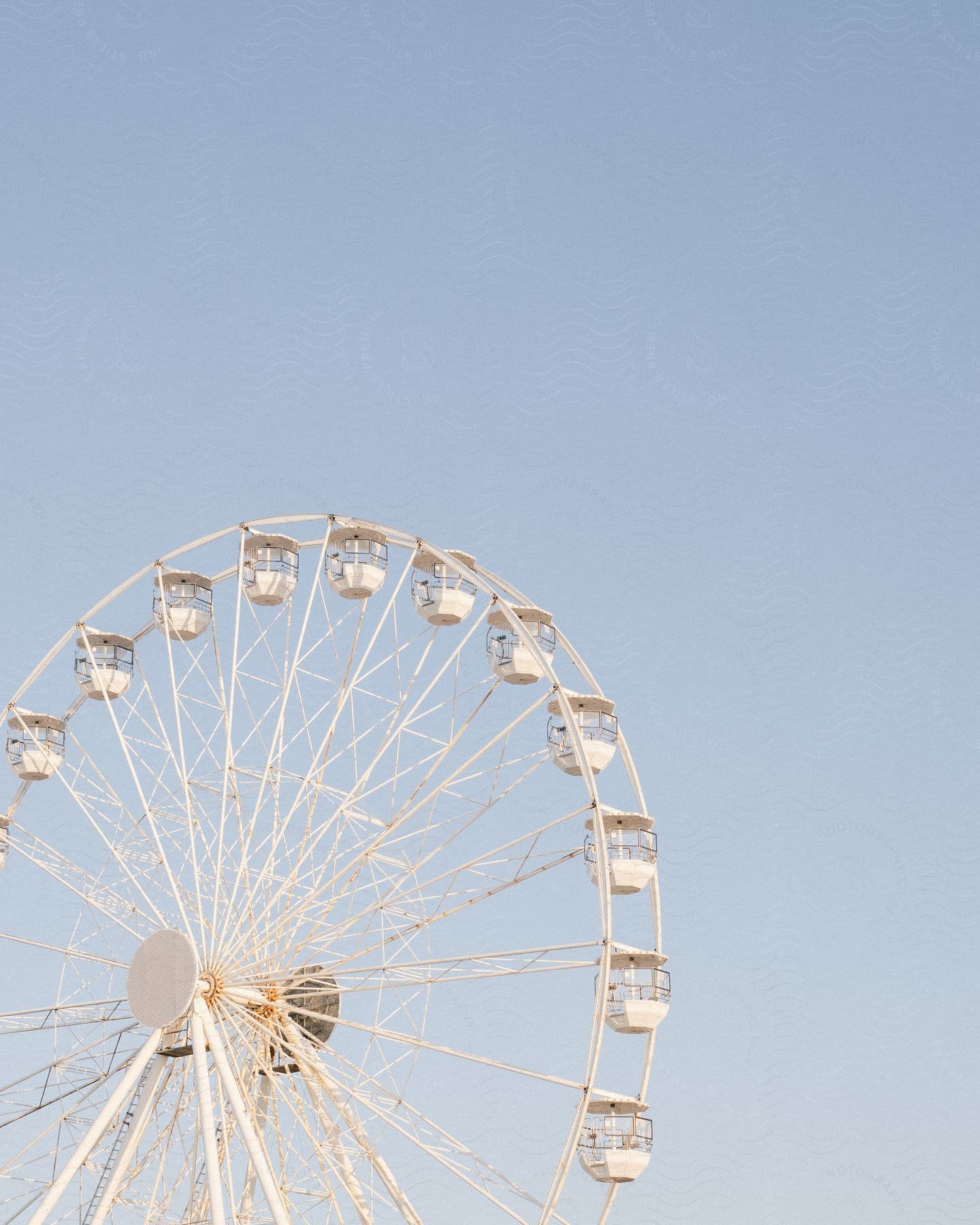 A white Ferris wheel against a blue sky