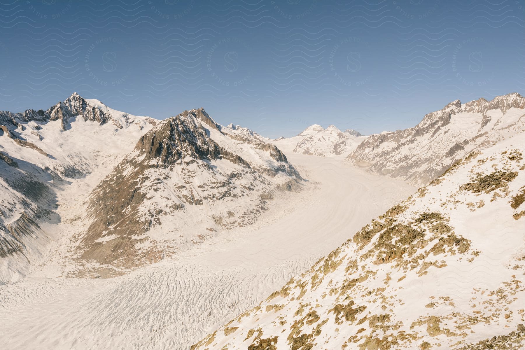 Mountainous landscape covered by snow and under a clear sky.