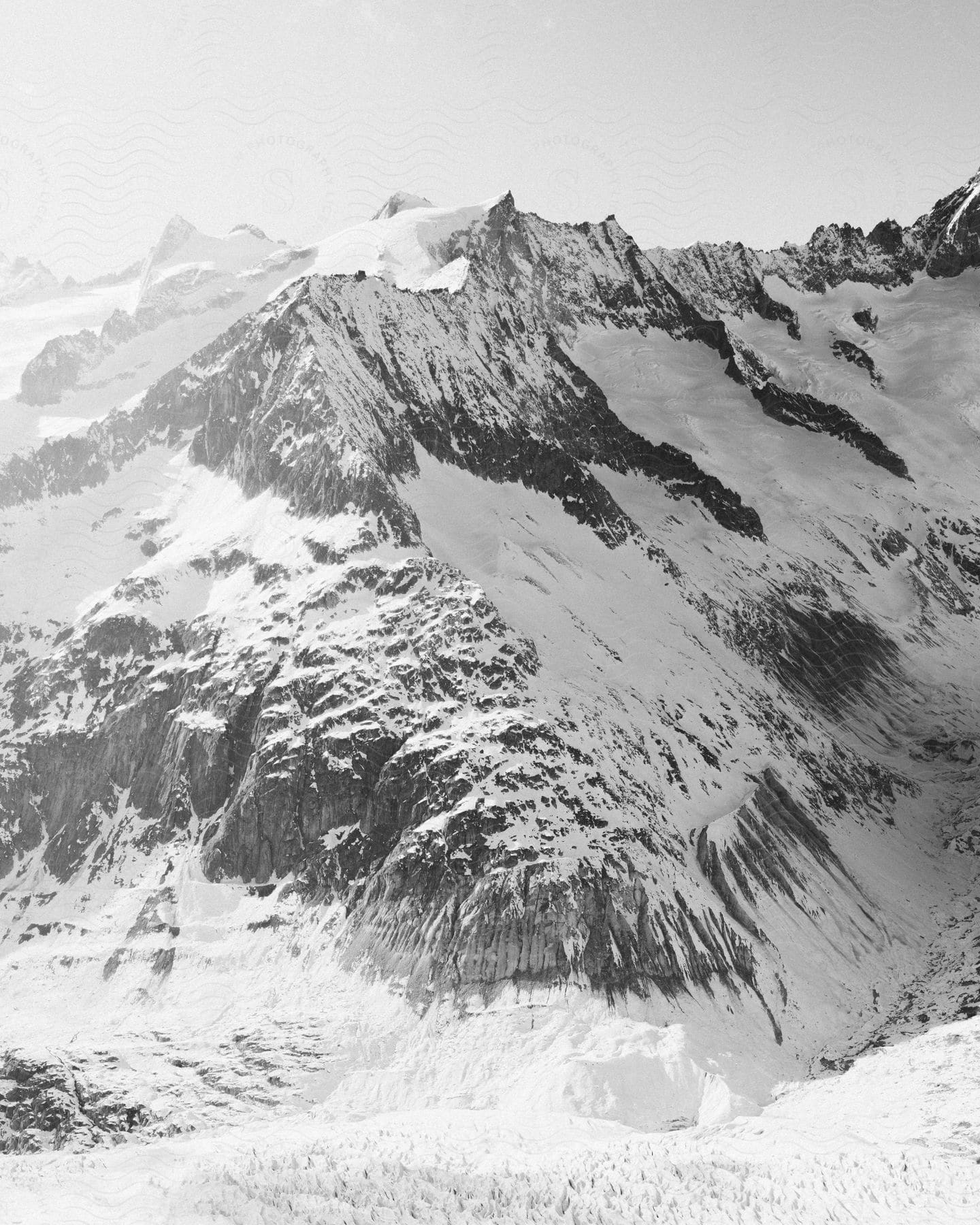 Snow covered mountains with steep slopes and rough peaks high in the sky