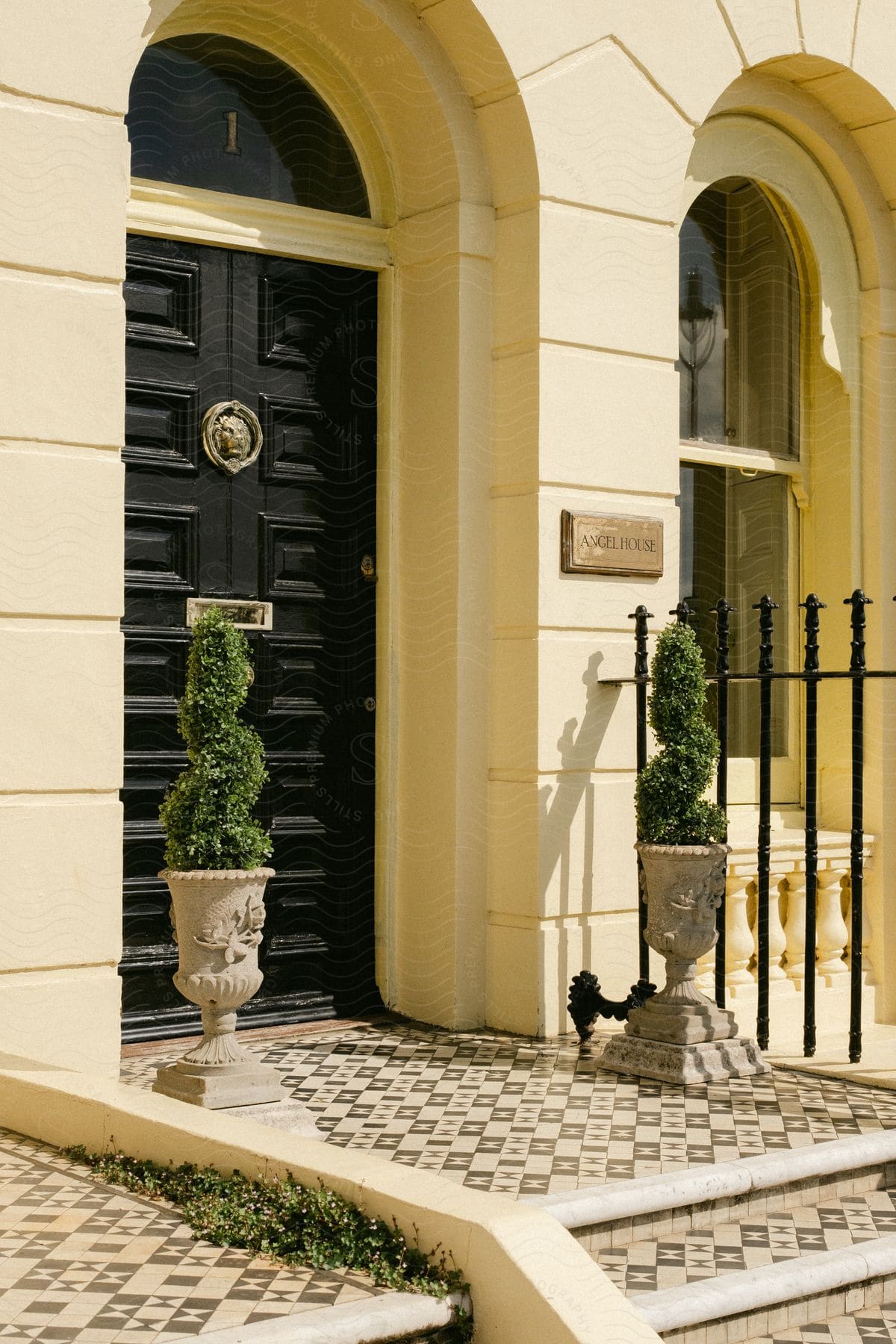 A stone residence has a name plaque called Angel House on its front wall.