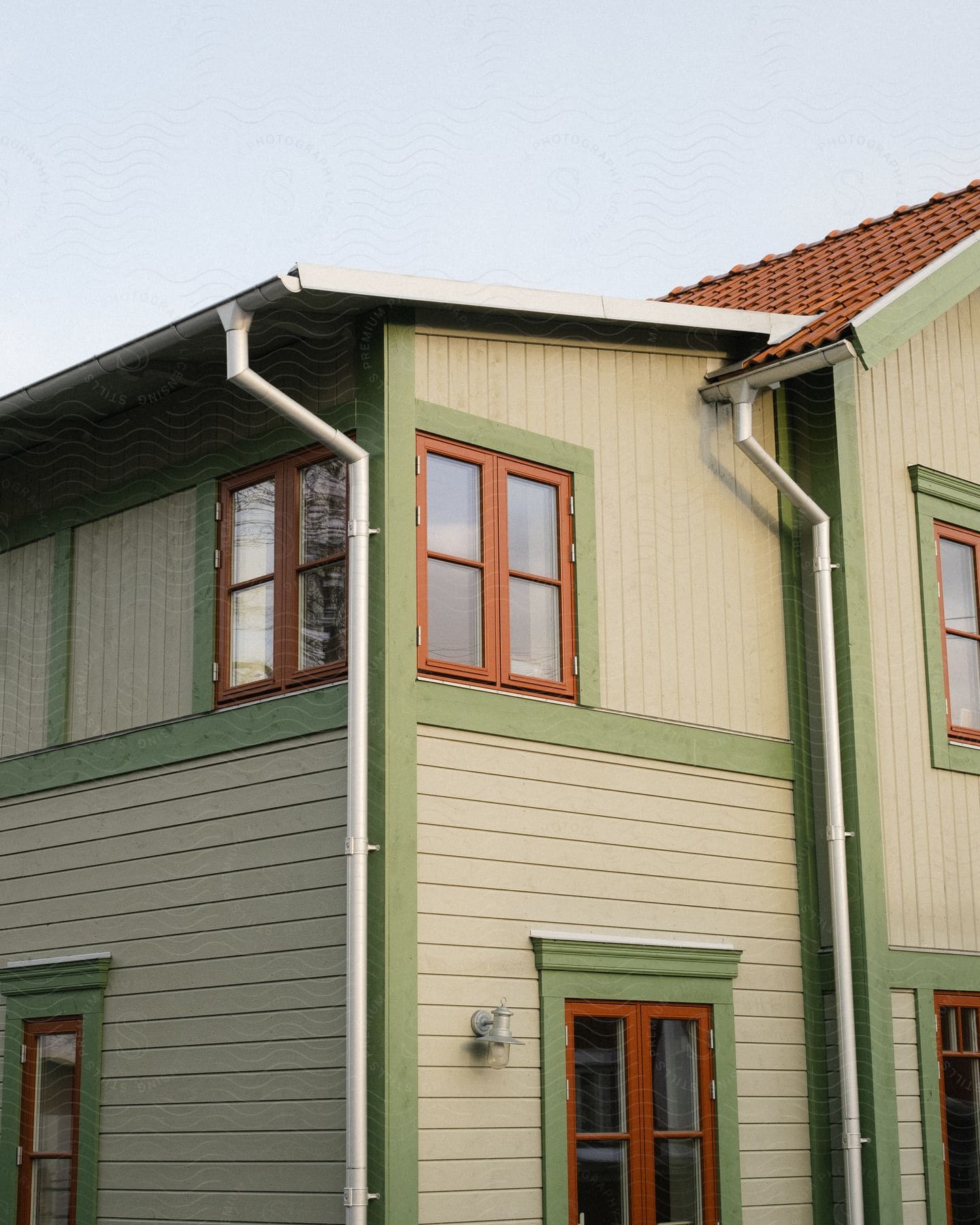 House with roof gutter drainage pipes near the windows