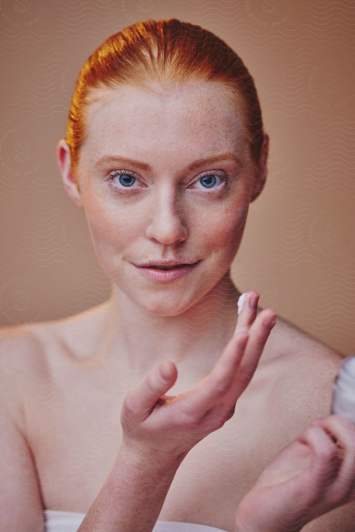 A woman about to apply a cream to her face in order to figure out how she wants to approach the application of the cream