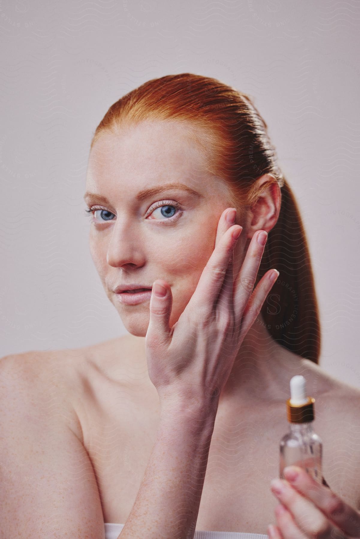 A woman putting oil on her face