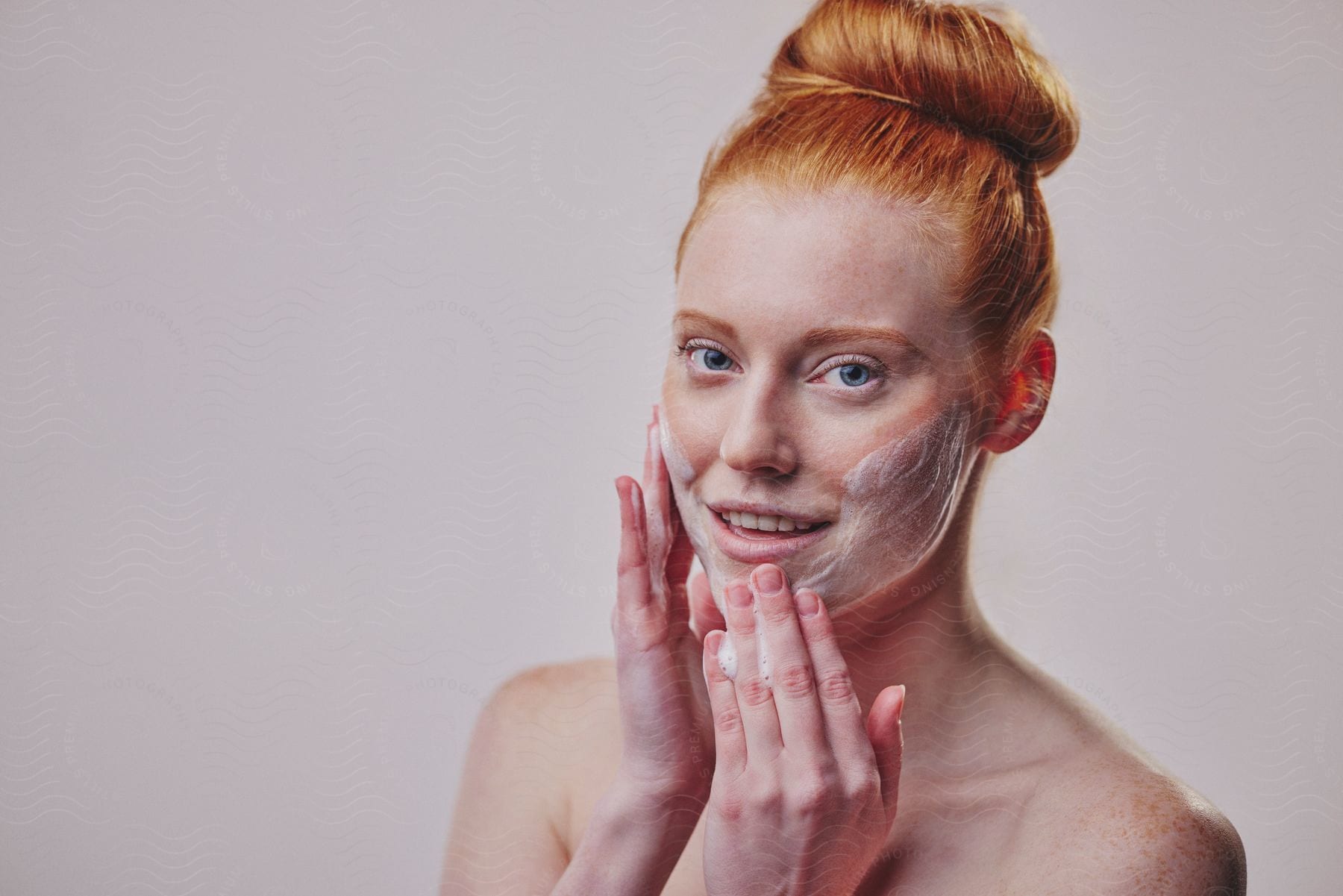 A woman putting skin care cleaning items on her face.