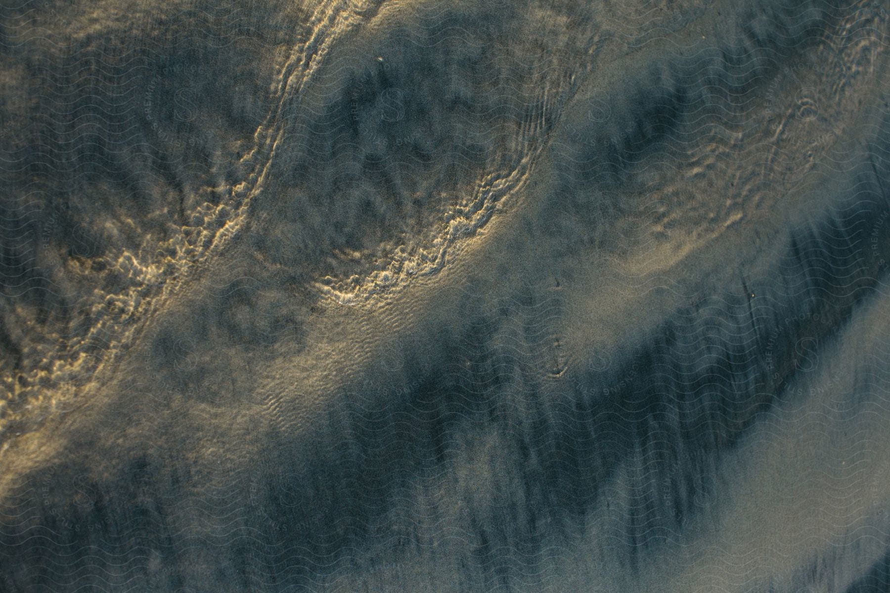 Earth's surface seen from above with ripples and shadows that create an abstract and natural visual effect.