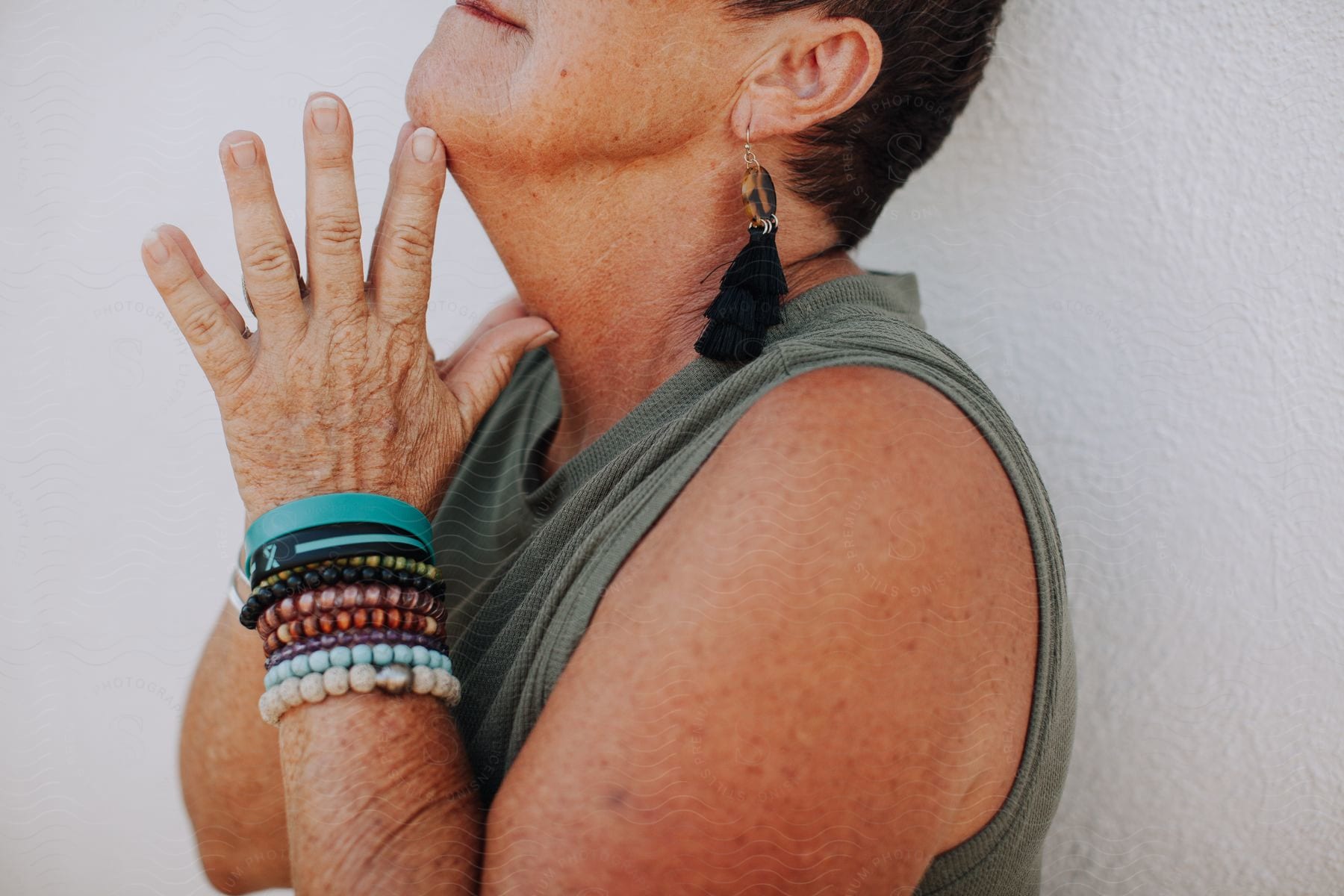 Woman With Several Colorful Bracelets And Earrings With Her Palms Joined Together In A Symbol Of Prayer