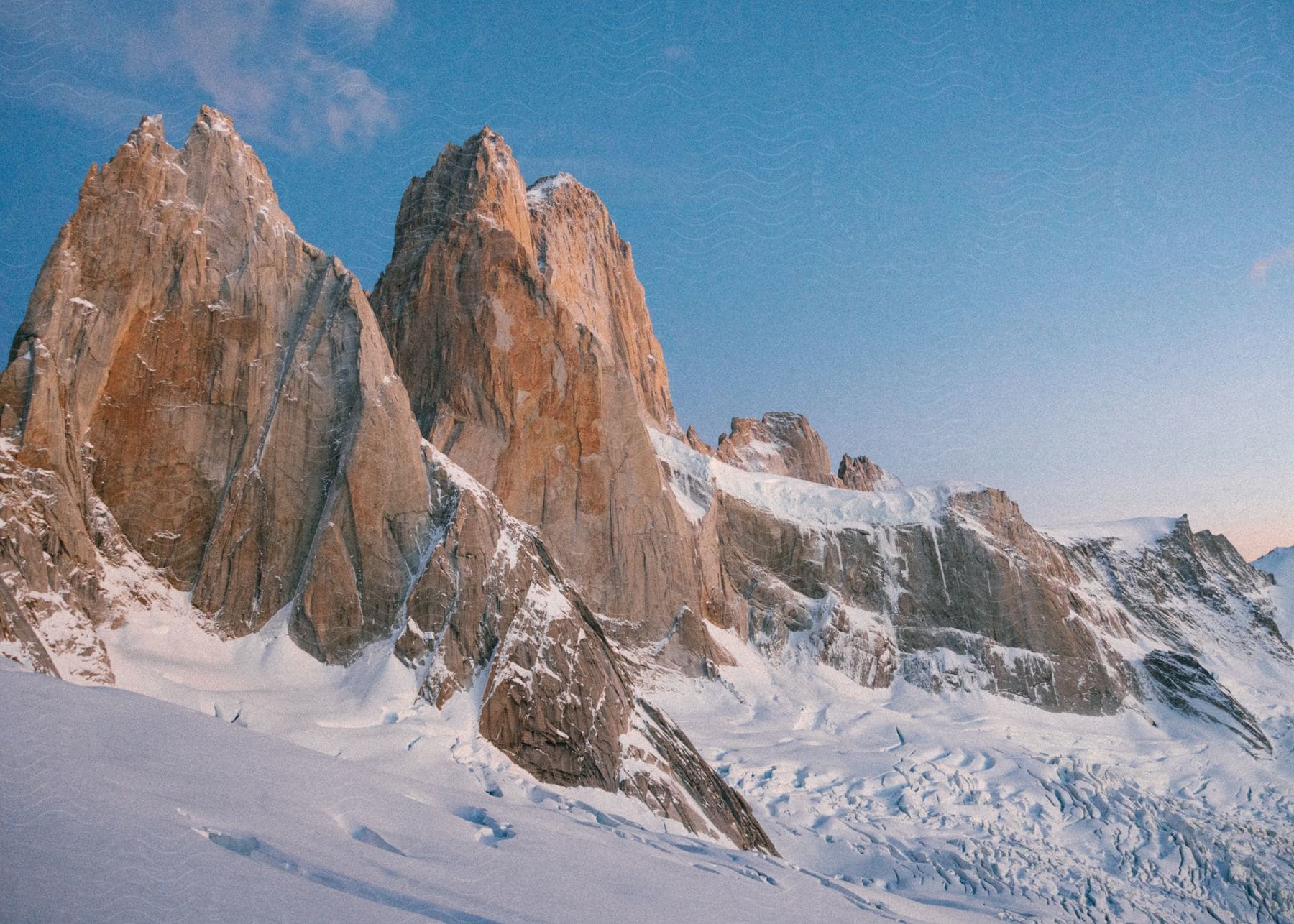 A majestic view of snow-capped mountain peaks under a clear sky.