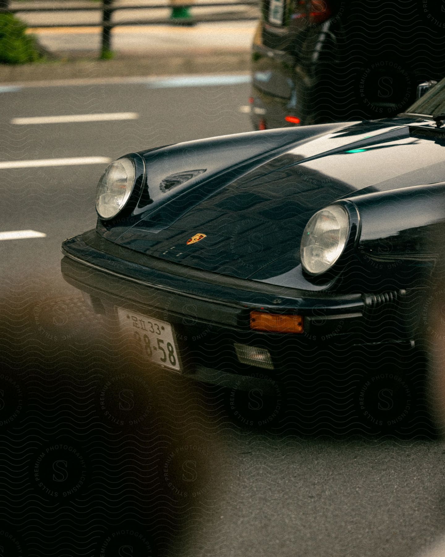 Black sports car on a road as a van travels the other way