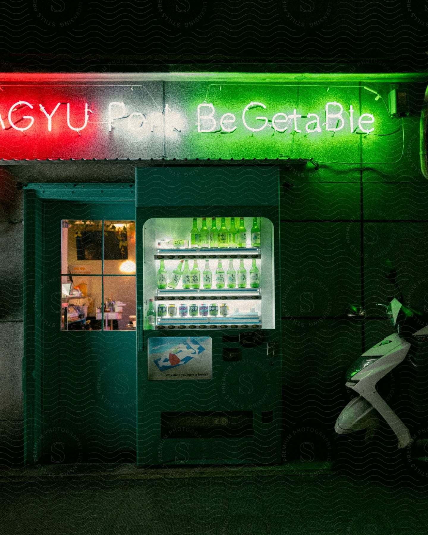 A green bottle drinks machine in an exterior with a white motorbike and on top written in red and neon green