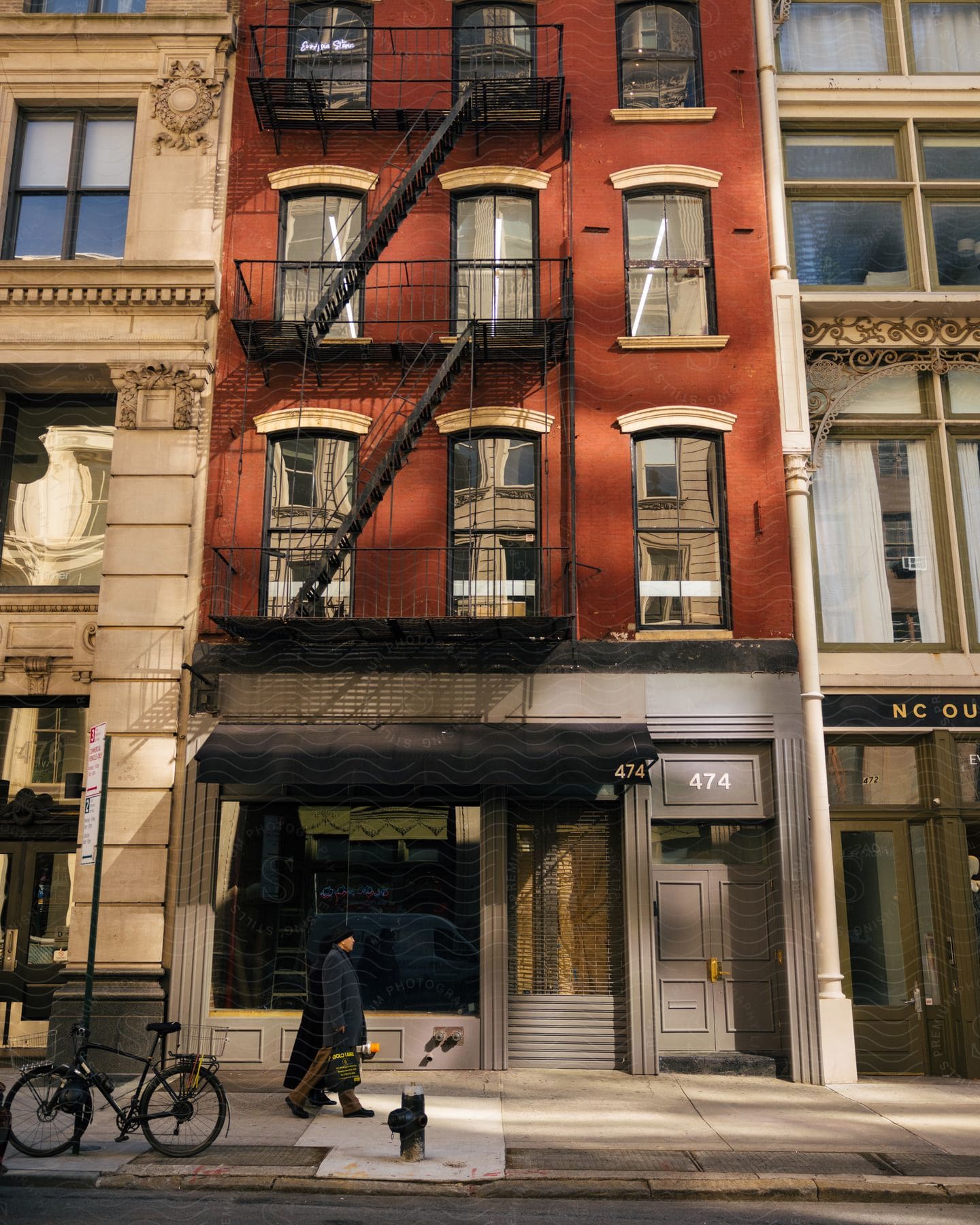 People walking down a sidewalk in front of a building.