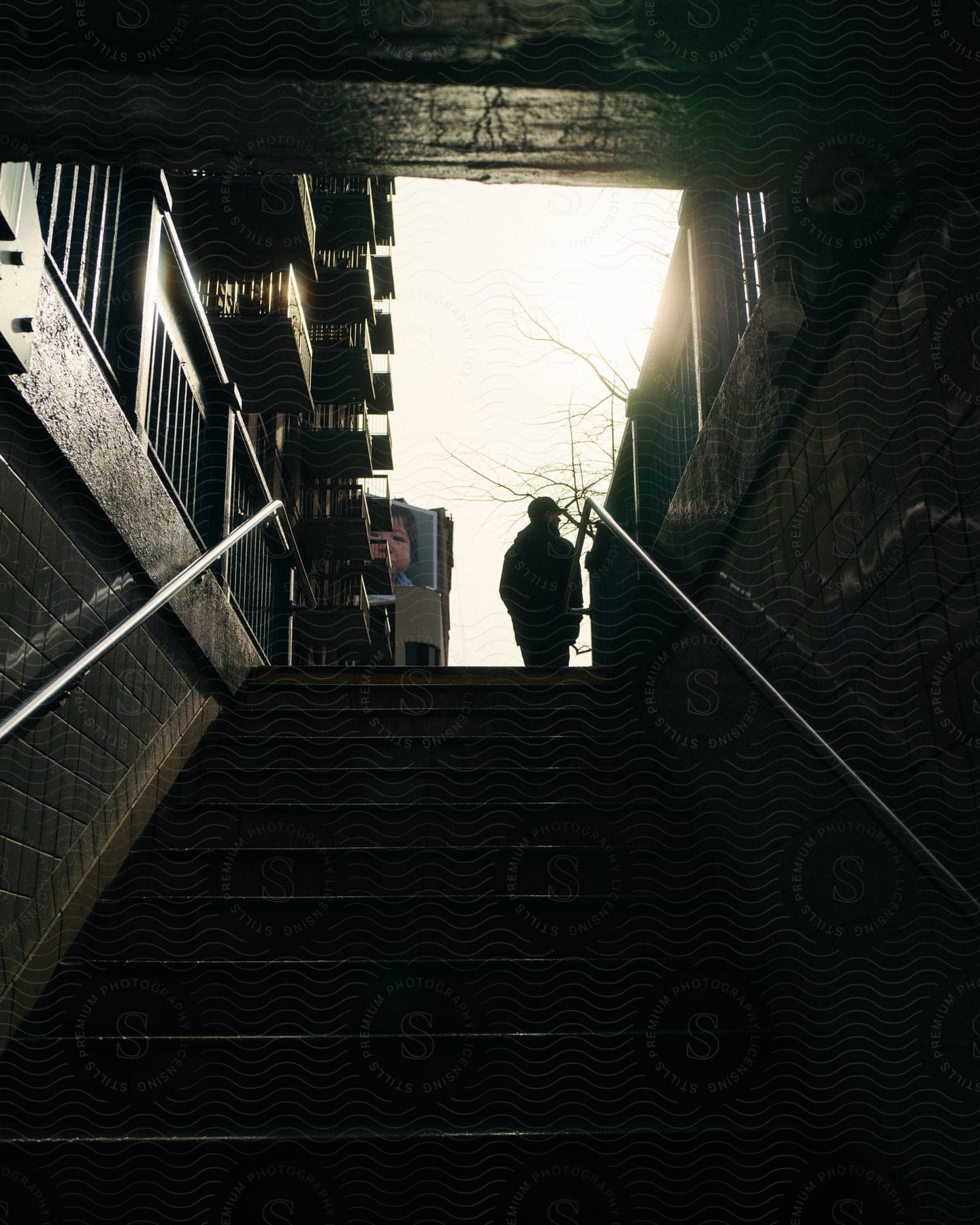 Silhouette of a person walking on a dark stairway and the sky above