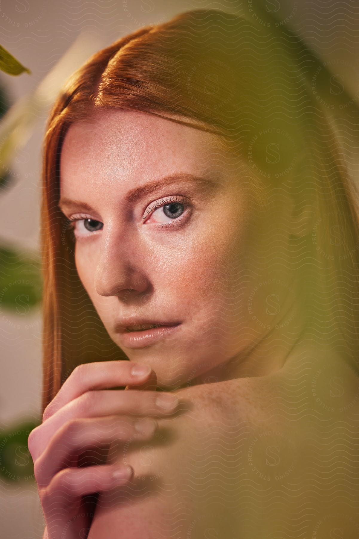 A portrait of a woman on a sunny day near a plant.