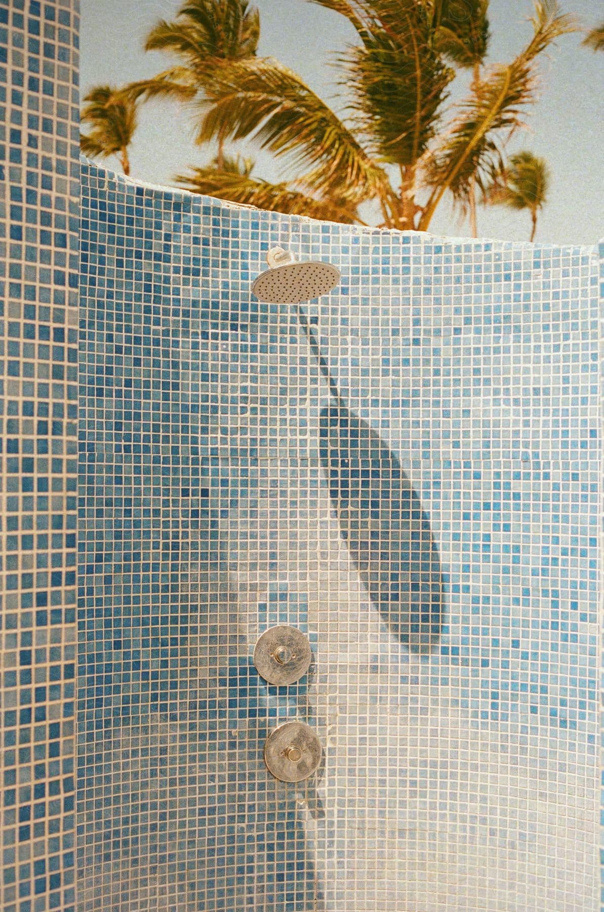 Stock photo of beach shower in an open-air environment with a blue tile wall