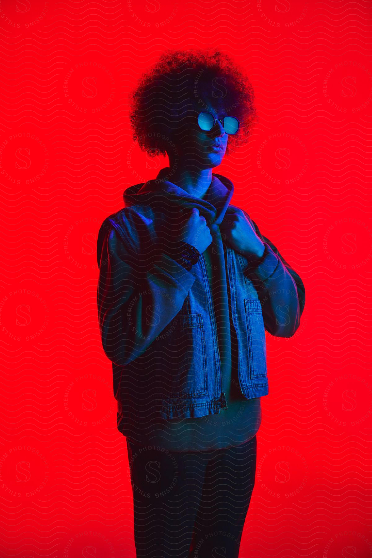 A man modeling some clothes in a red room