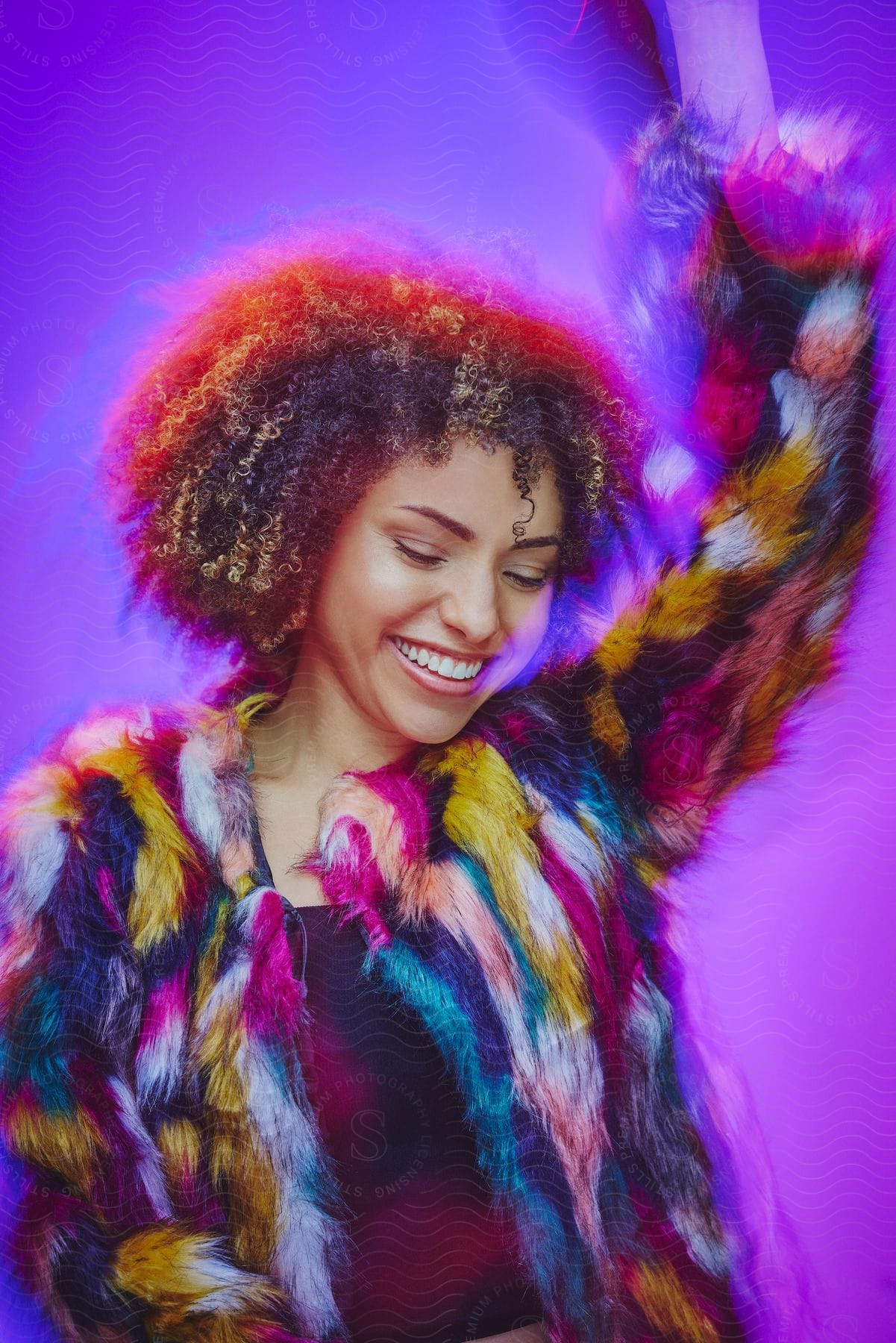 Smiling model woman posing in a colorful cardigan against an electric purple background