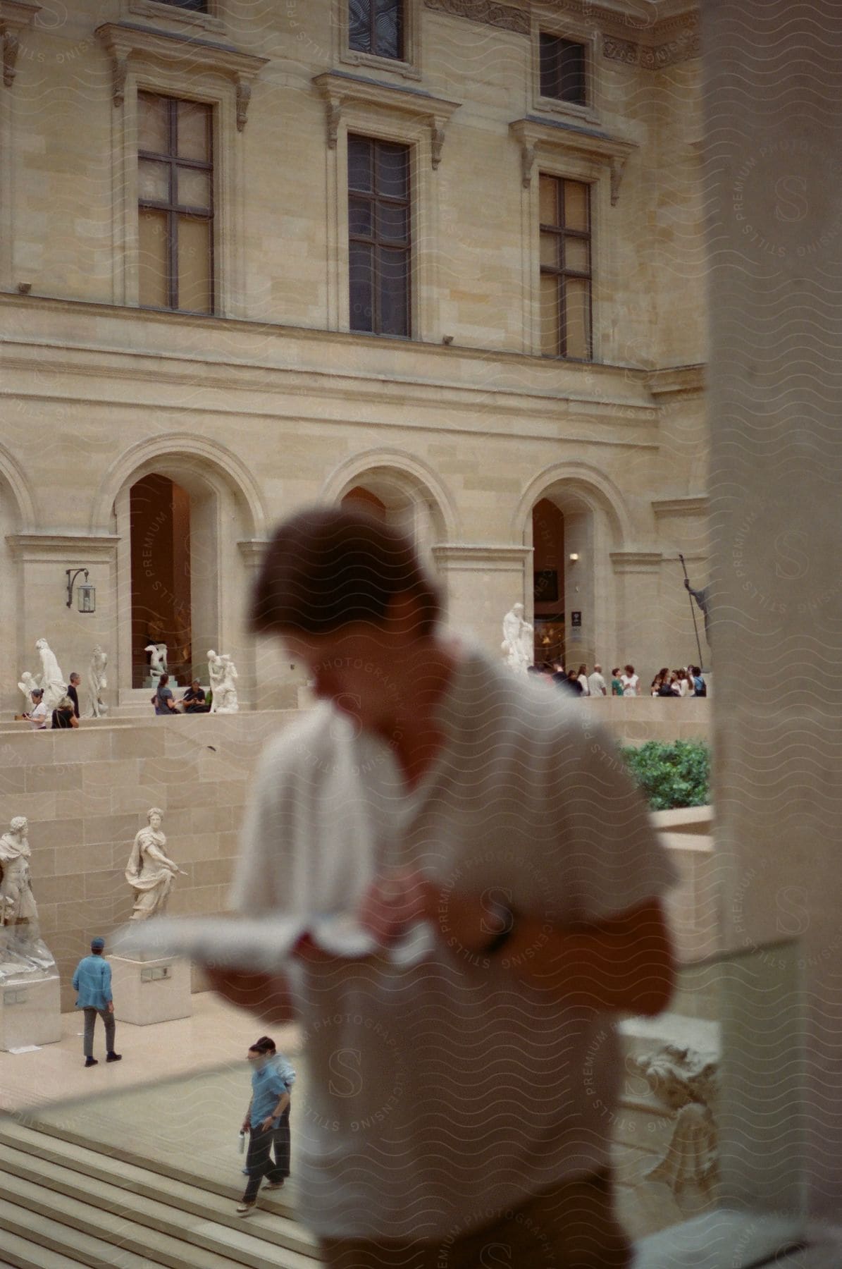 Man reading a brochure inside a classic, historic building.