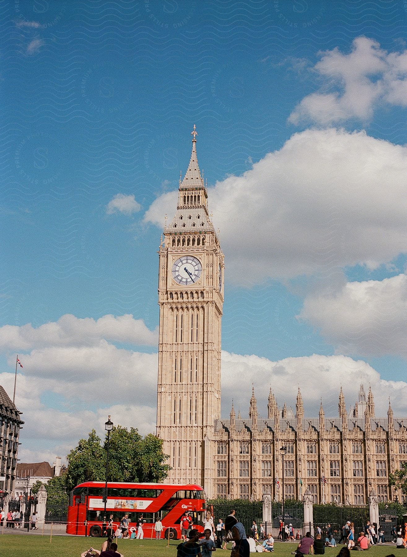 People on the street and bus passing the clock tower on Parliament Square in London