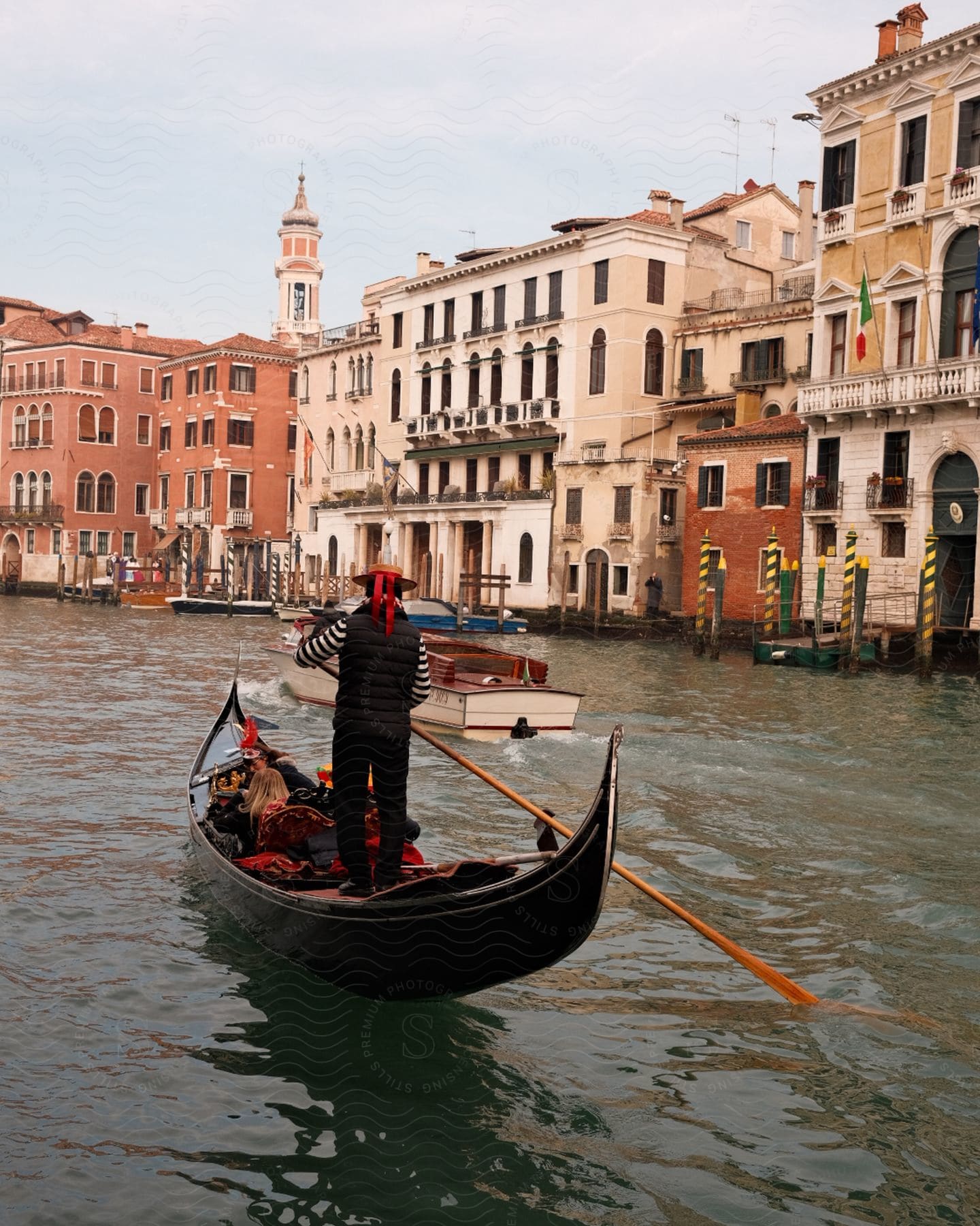 People in a gondola floating on a channel in Venice.