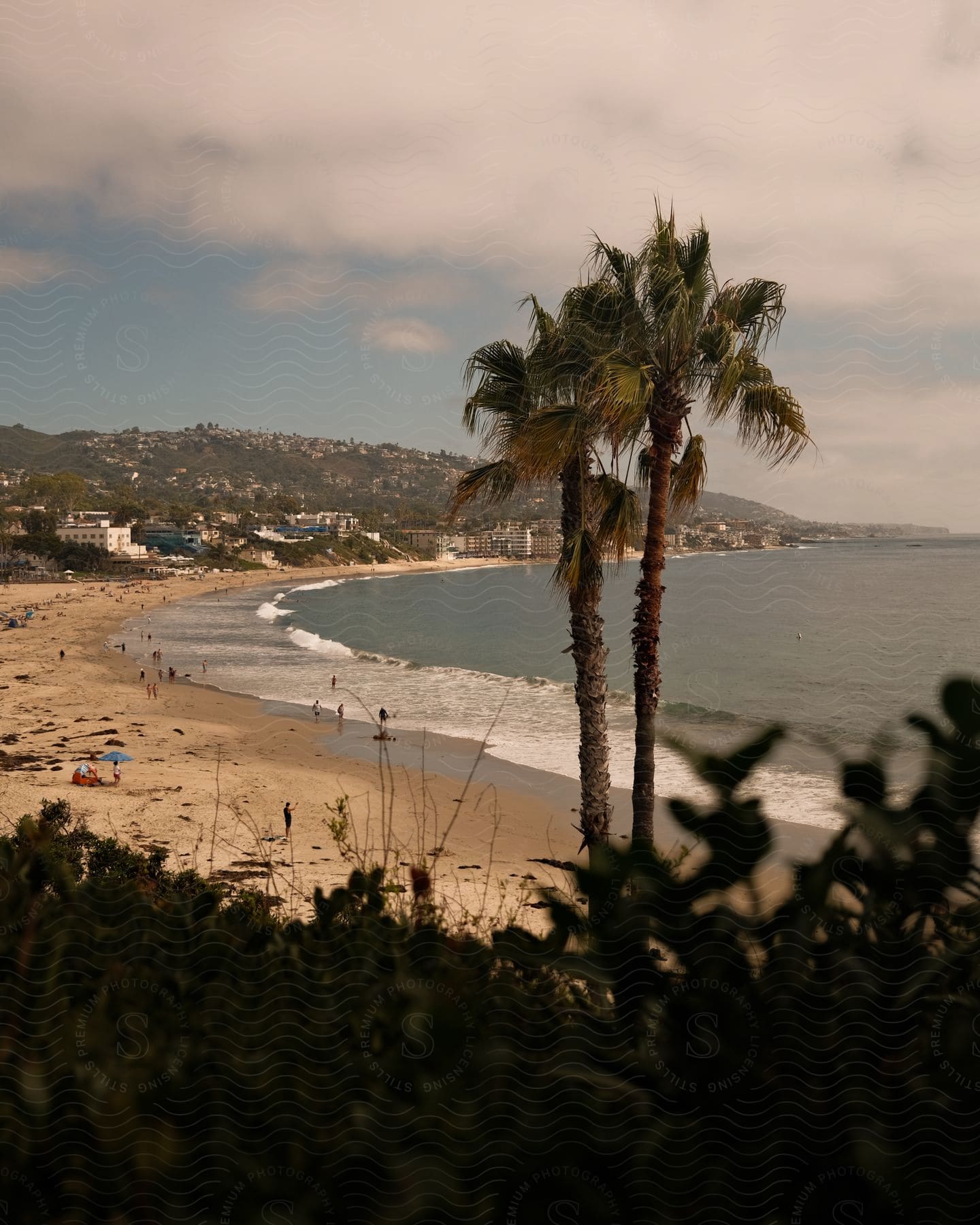 People are on the beach during a cloudy day.