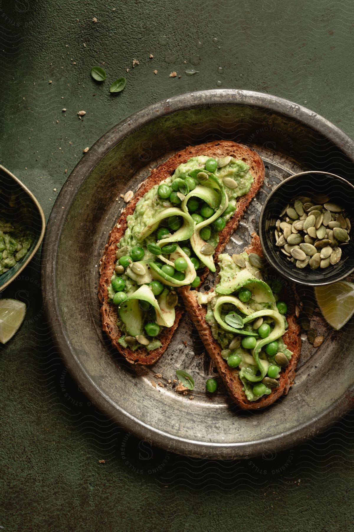 Avocado toast on a metal plate on a table.