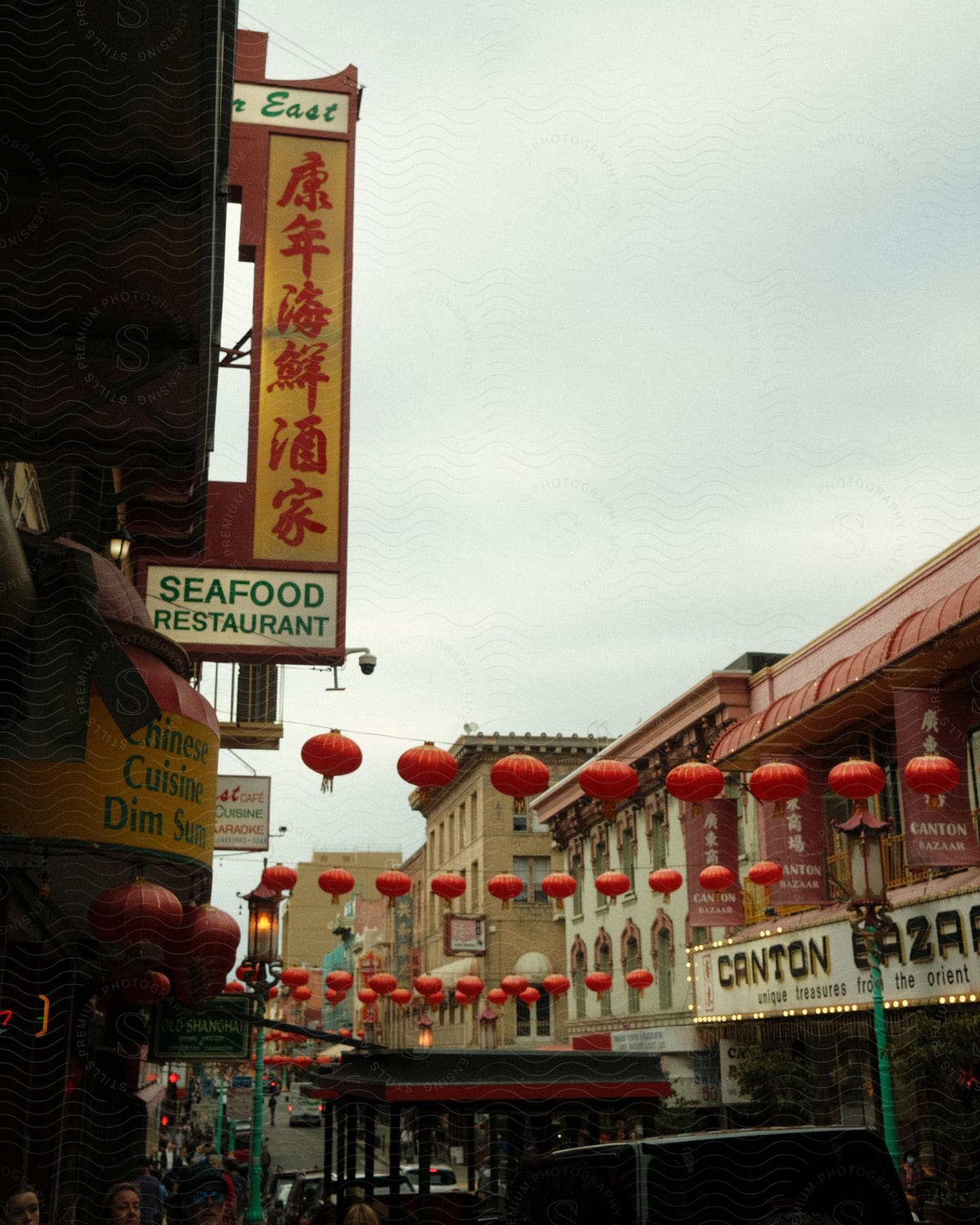 A busy street is lined with stores and restaurants with signage made out in Chinese.