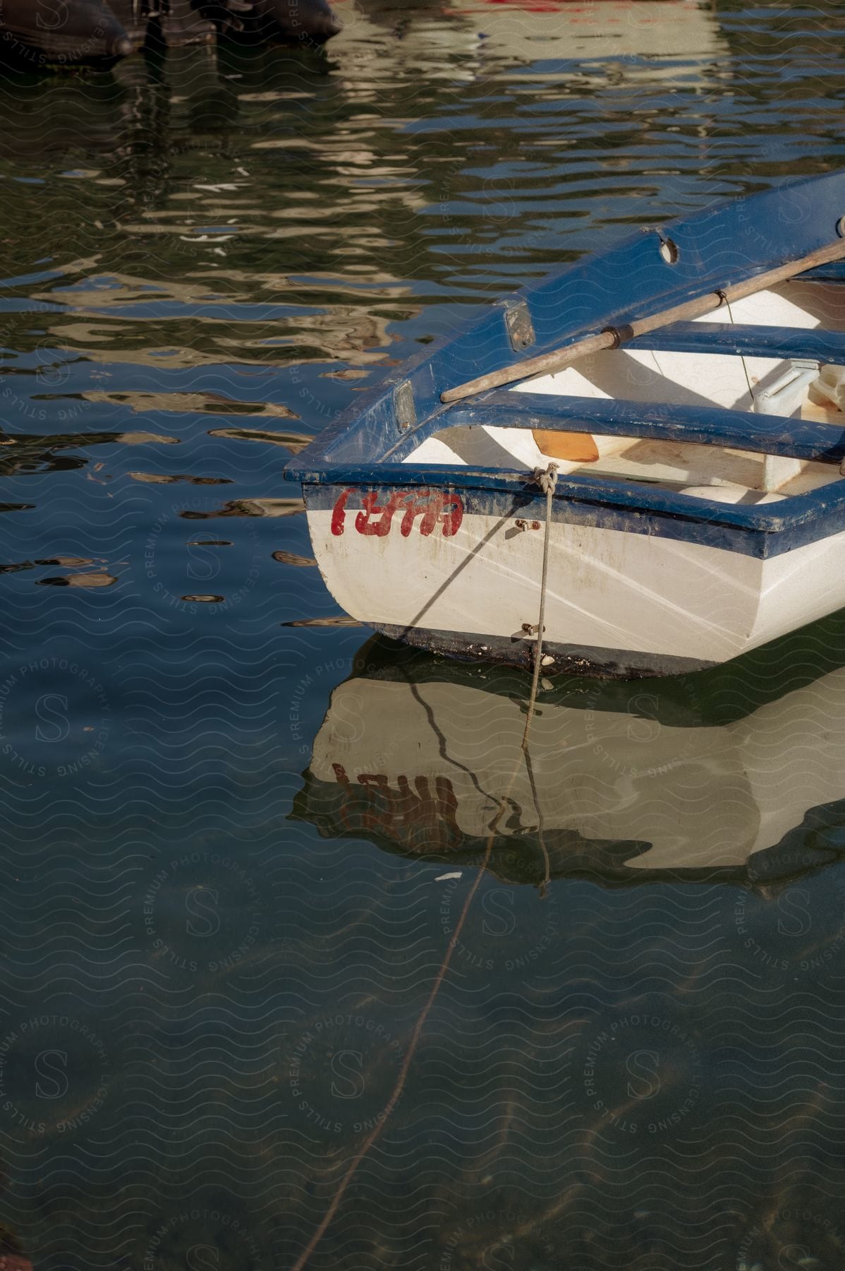 A small wooden boat is moored on a body of water.