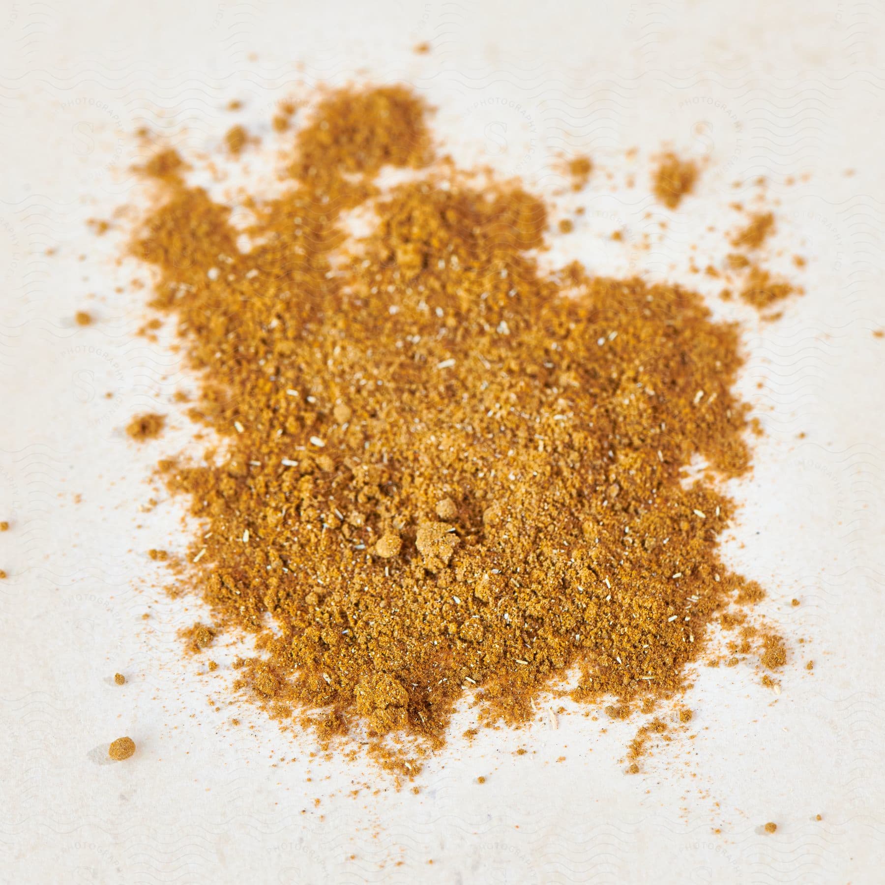 Close up of orange powder substance with white flakes on a white background