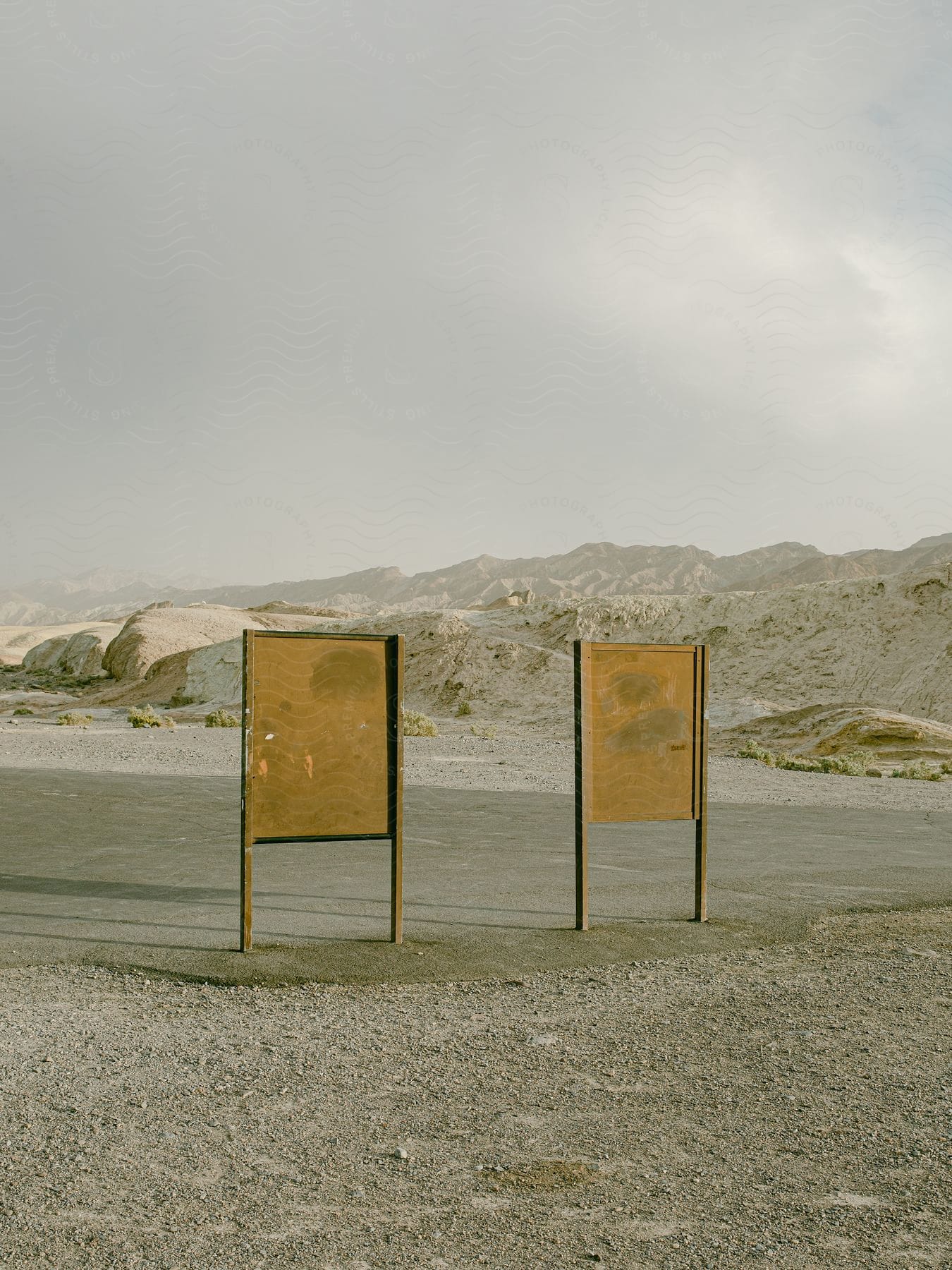 two weathered signs resting against each other in a desert landscape