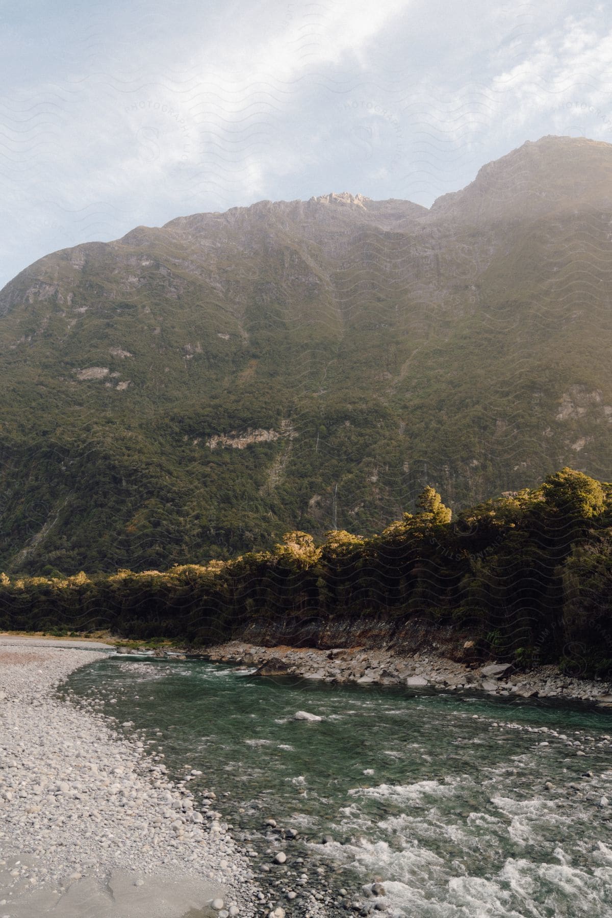 A river at the base of a mountain range on a sunny day