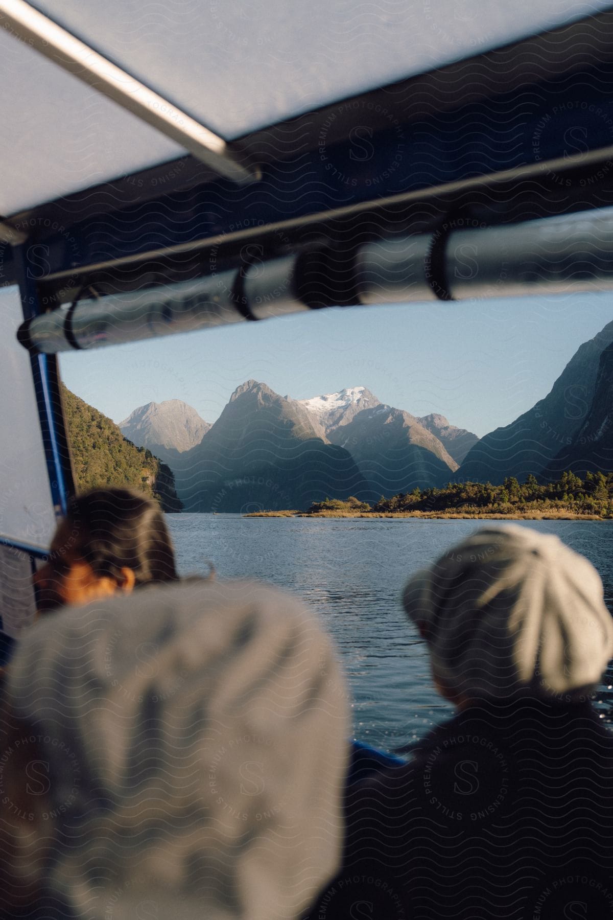 A tourist boat on a body of water overlooking a mountain range.