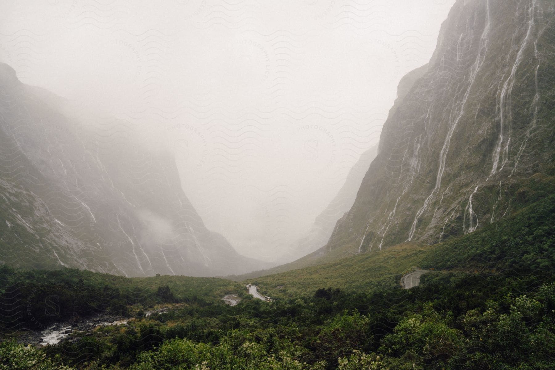 Natural landscape with river trees and mountains on a misty day