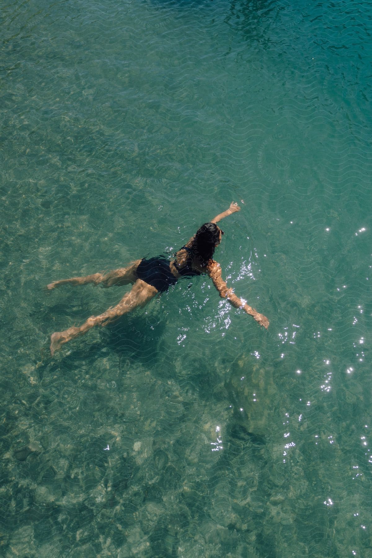 Aerial view of woman swimming in clear water