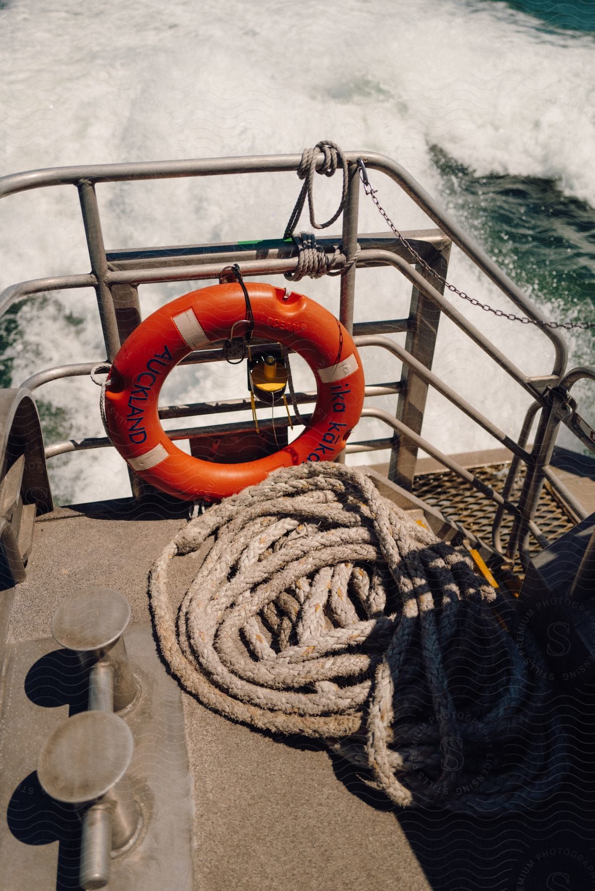 A red buoy stuck in the handrail of a boat that is sailing in the water