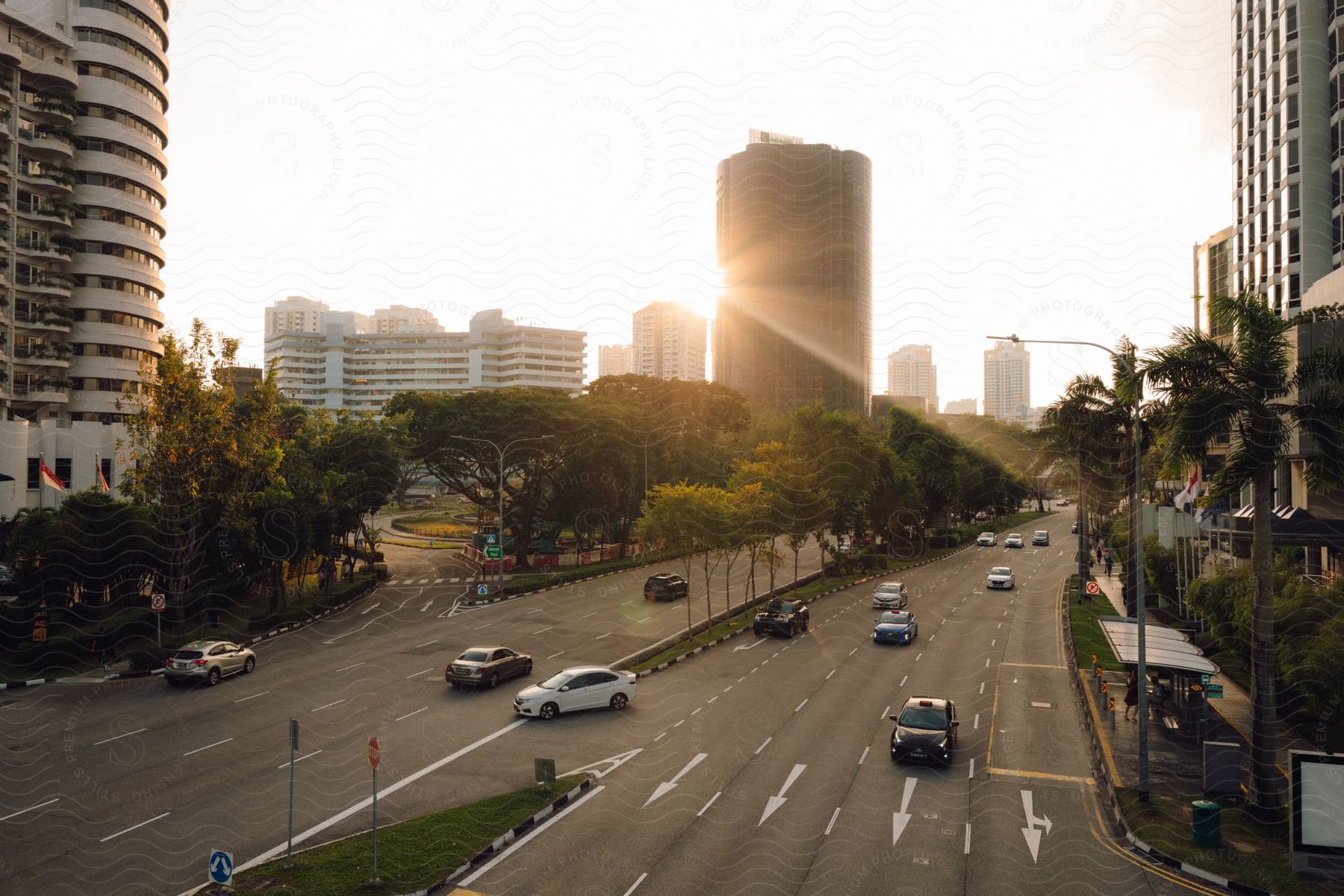 Sun shines past building onto multi-lane city street