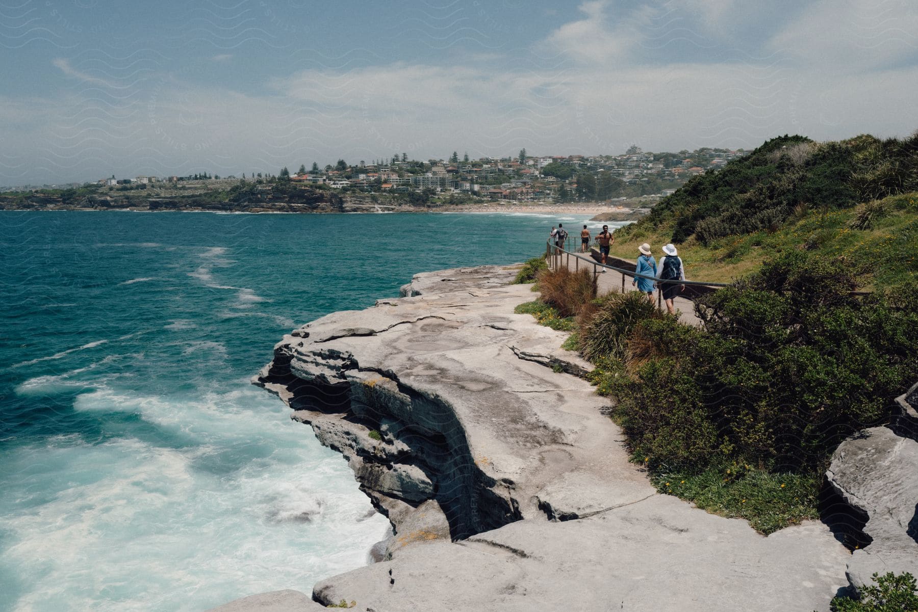 A group of people walking along The Bondi to Coogee Walk, enjoying the coastline vistas