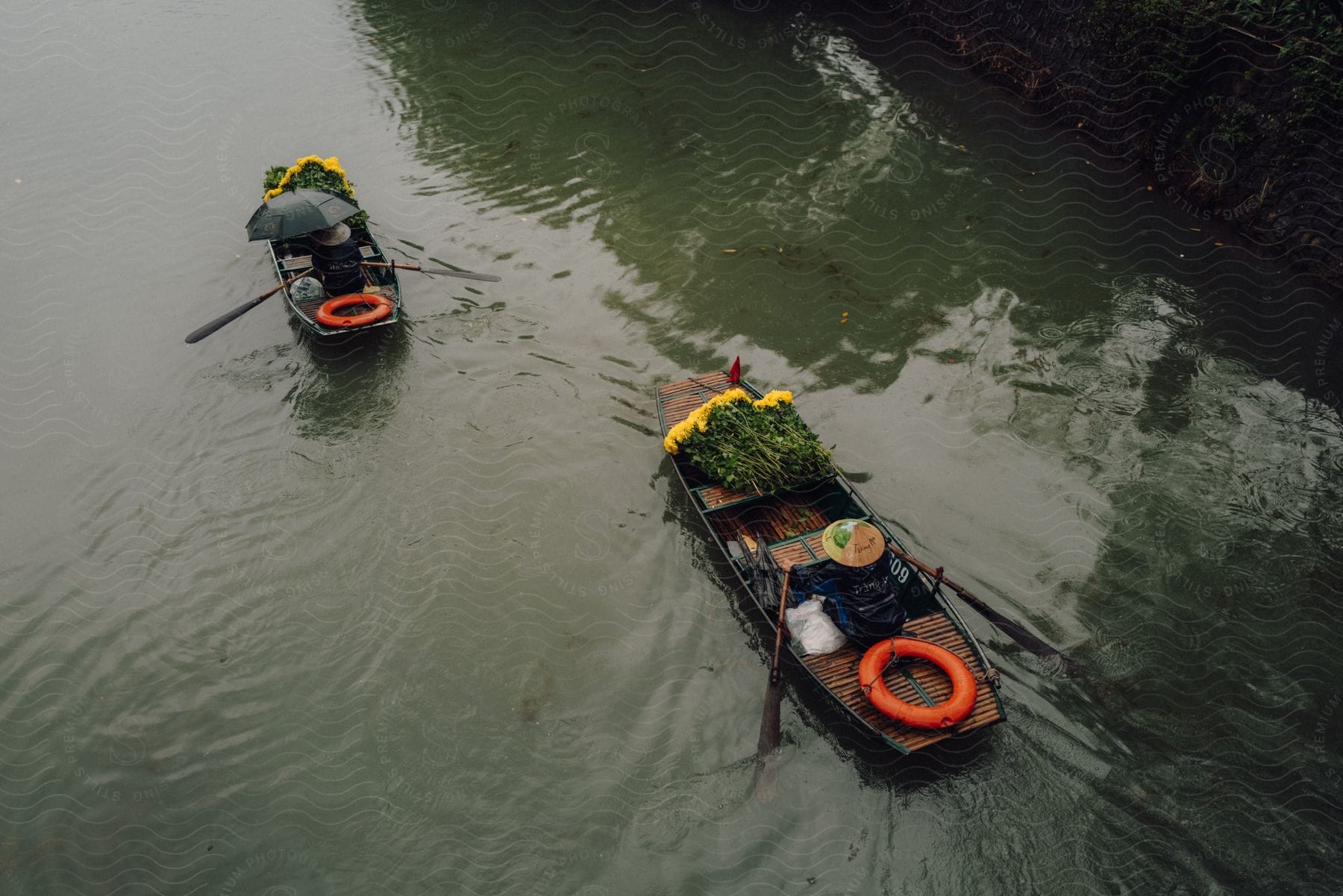 Oriental canoes with flowers traveling along a river channel