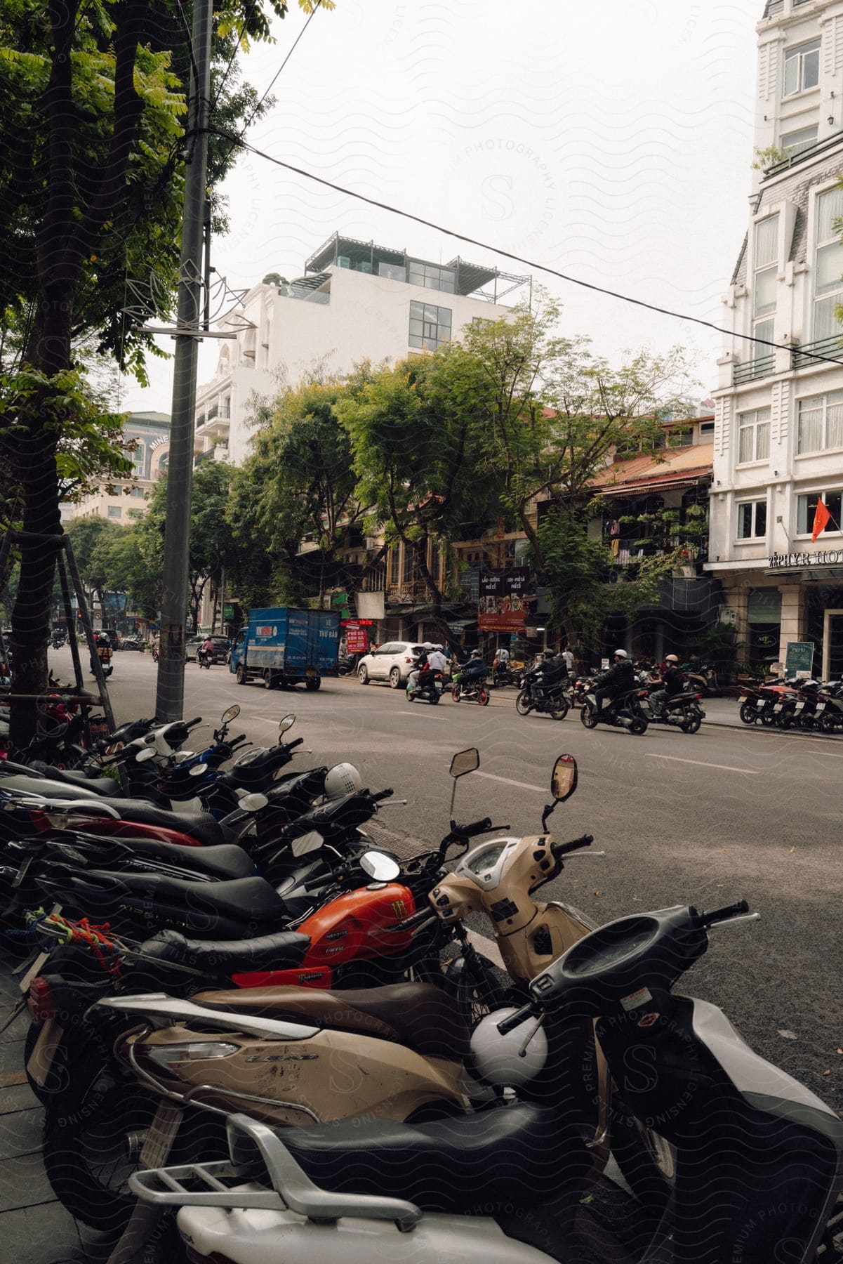 A row of colorful motorcycles are parked neatly on the side of a city street