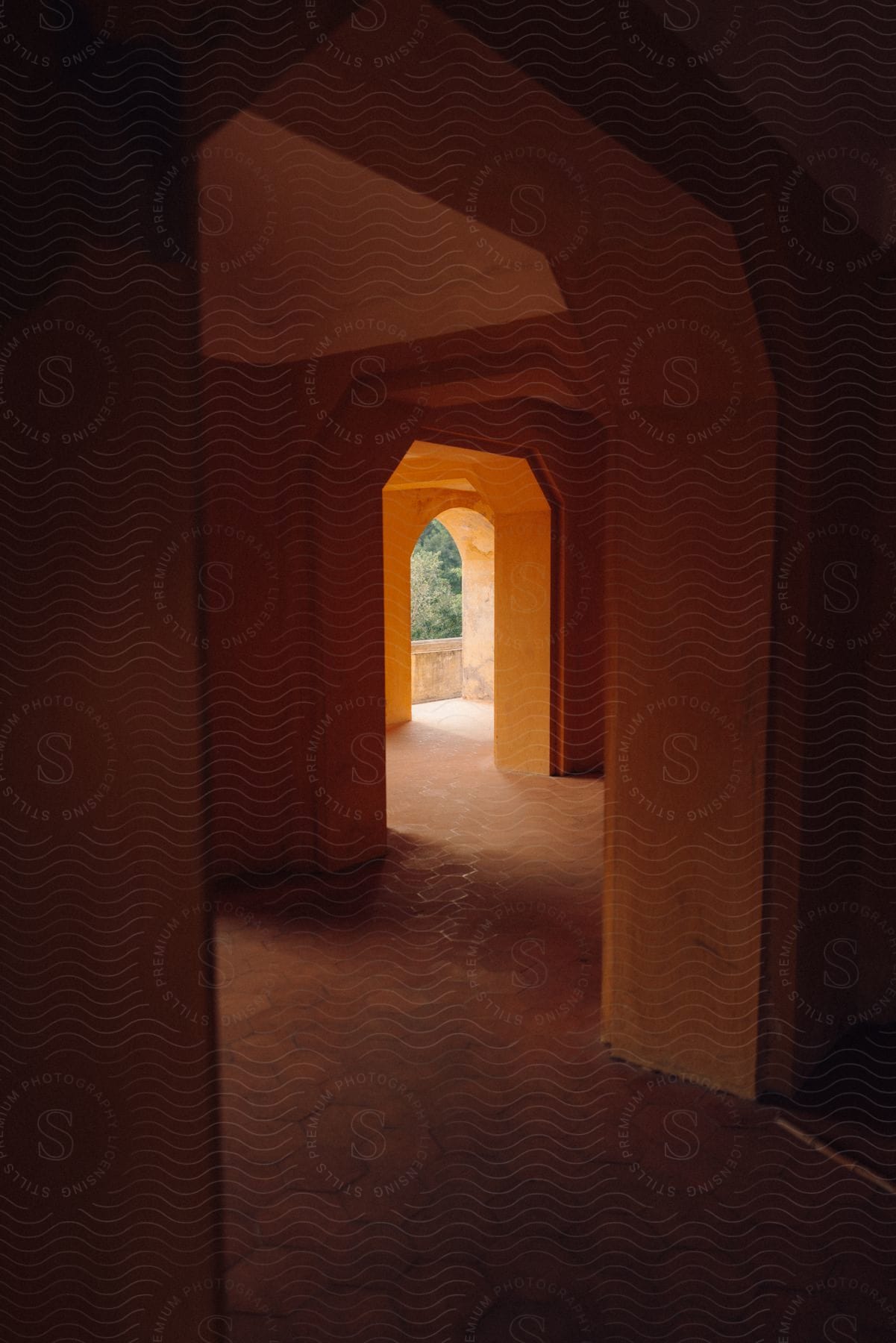 a long, narrow hallway with a rounded archway leading to a balcony