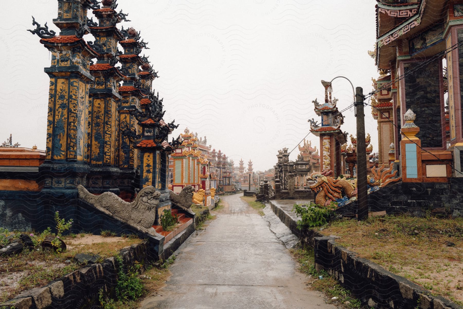 Colorful ornate Asian architecture lines path at tourist destination.